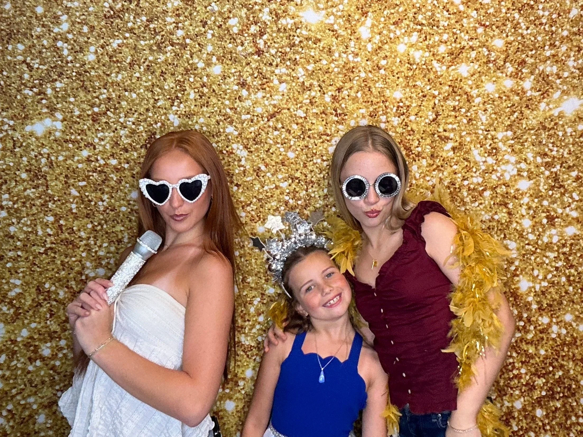 Guests posing together in front of a gold glitter backdrop at a end of year celebration using a Pop & Pose Photo Booth in Lake Mary, Florida. Our Photo Booth rentals are perfect for weddings, corporate events, and school celebrations.