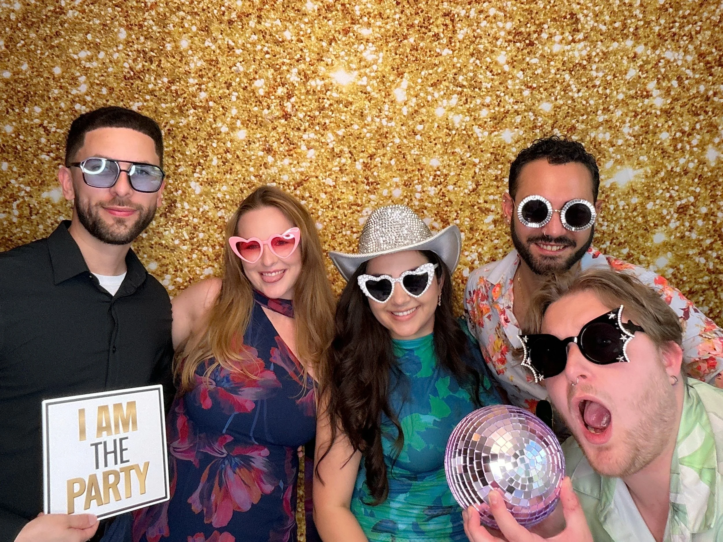 Guests posing with fun props and sunglasses at an Orlando Photo Booth rental by Pop & Pose Events.
