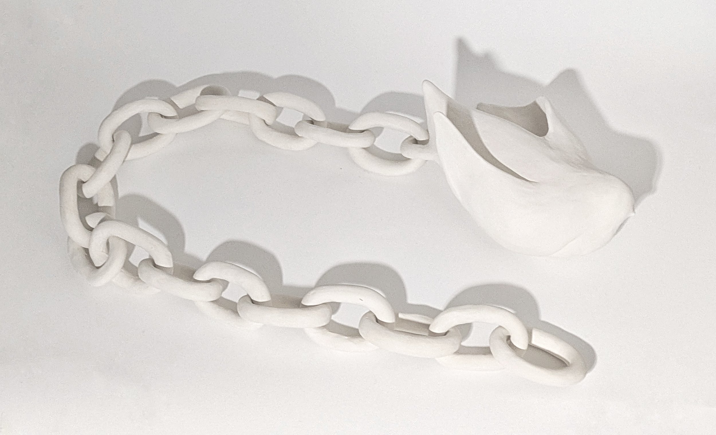 Scultura in ceramica bianca artigianale. Rappresenta una colomba incatenata.