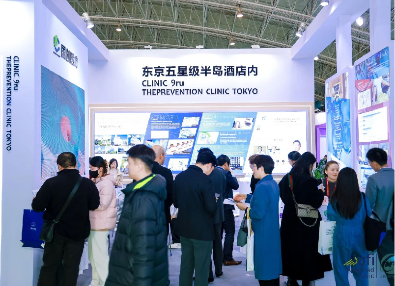 People attending a healthcare conference booth for the Prevention Clinic Tokyo, with informational displays and banners in Chinese, Japanese, and English.