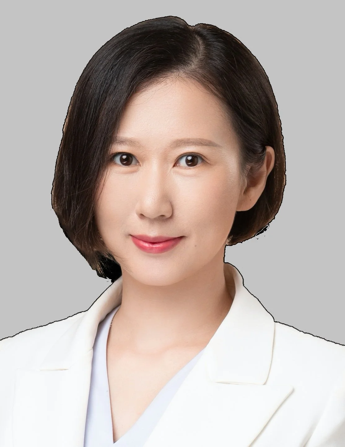 A portrait of a woman with short dark hair, wearing a white blazer and smiling, against a light gray background.