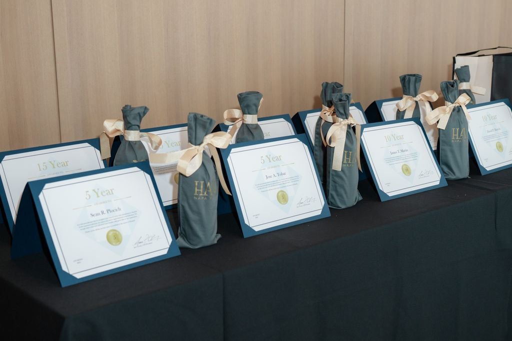 Awards and certificates displayed on a table, each titled for different year achievements and decorated with ribbons.