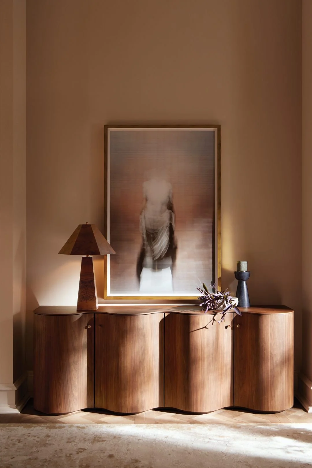Styled timber sideboard with lamp, artwork and warm layered interior décor.