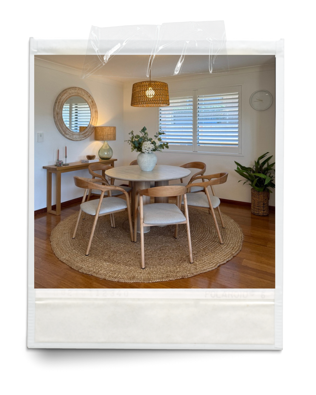 Styled dining room with round timber table, six chairs and warm neutral finishes.