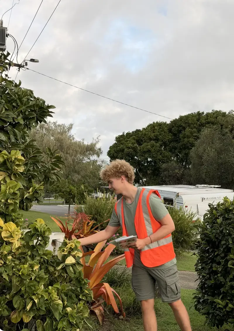 Noosa Flyer Co team member delivering a flyer into a letterbox in Noosa