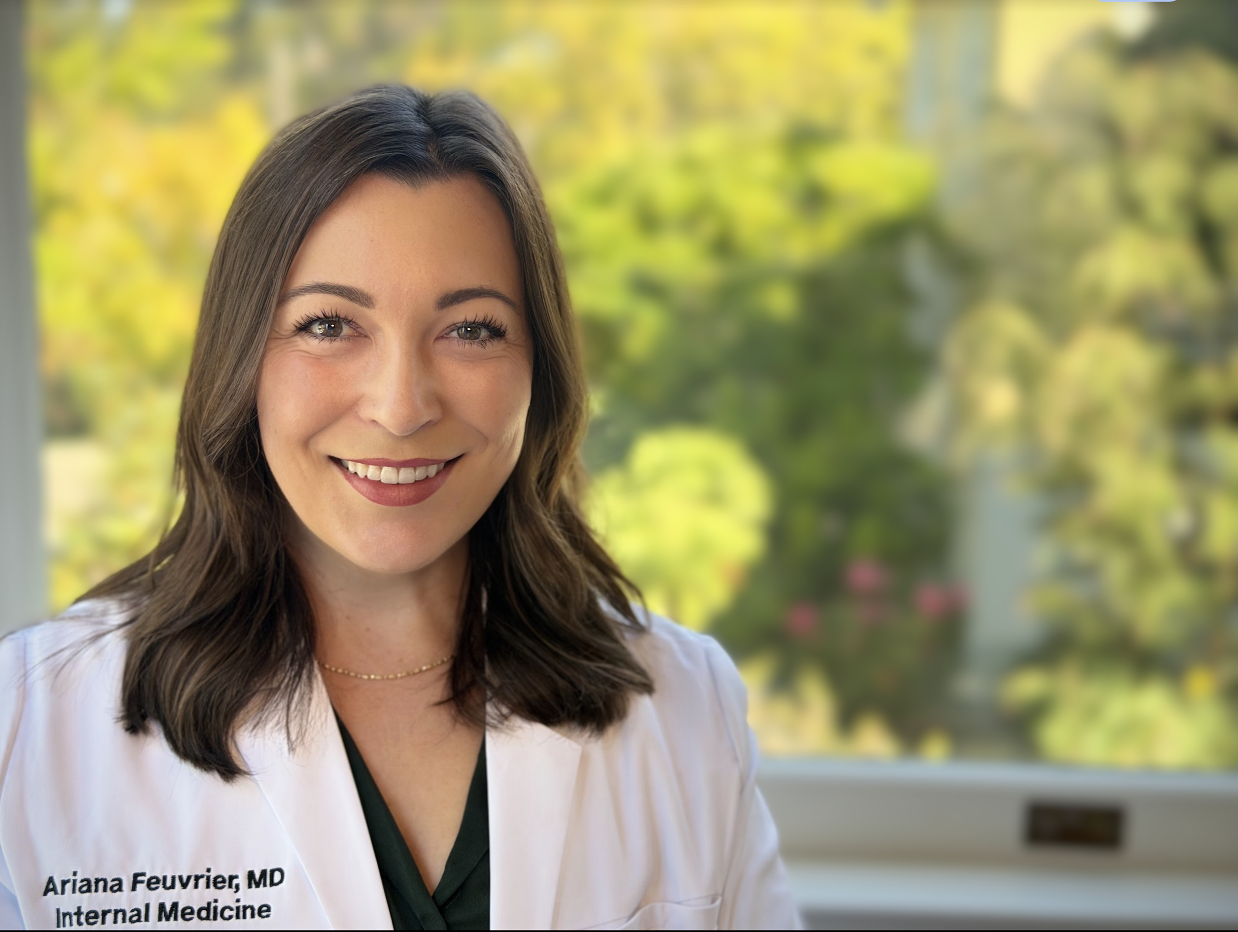 Portrait of Dr. Ariana Feuvrier, MD, in a white coat