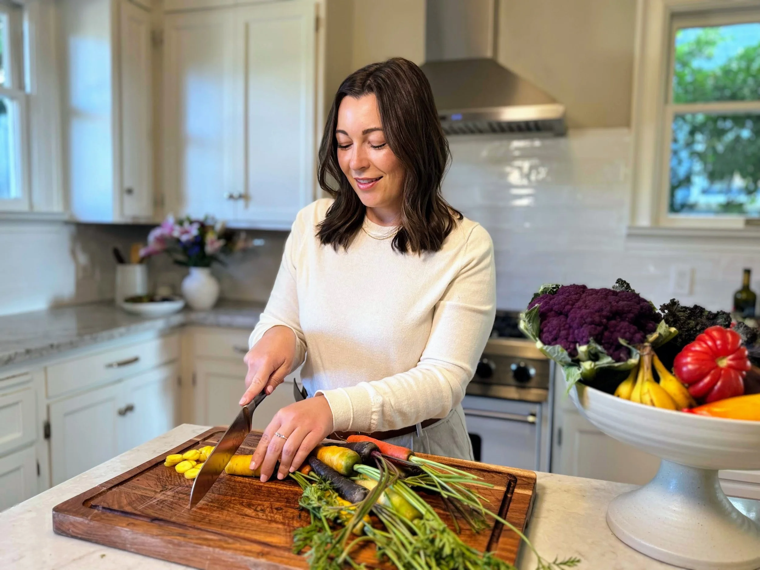 Dr. Ariana Feuvrier preparing fresh vegetables in her kitchen