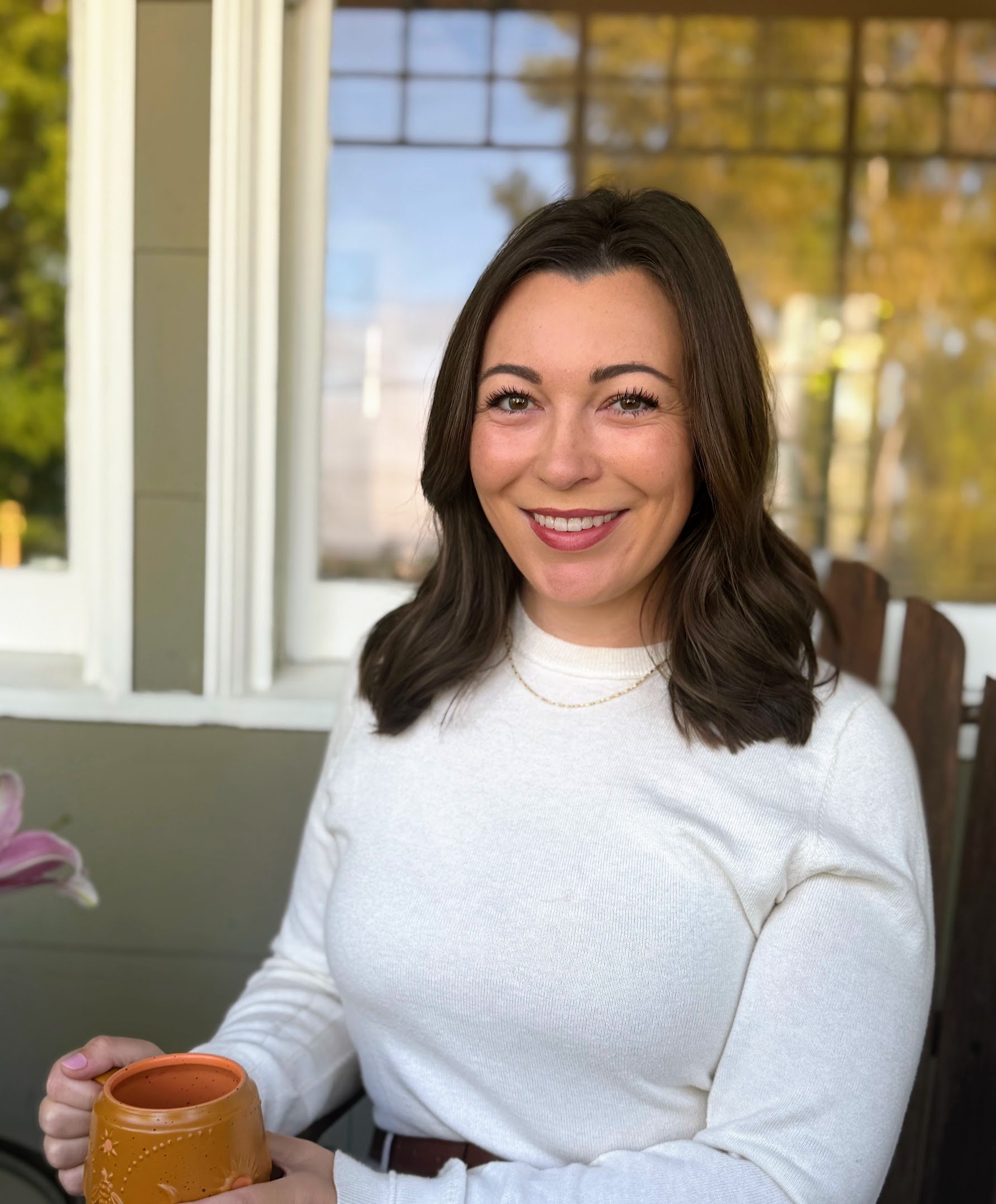 Dr. Ariana Feuvrier, MD, founder of Ardeur Health, smiling and holding a mug