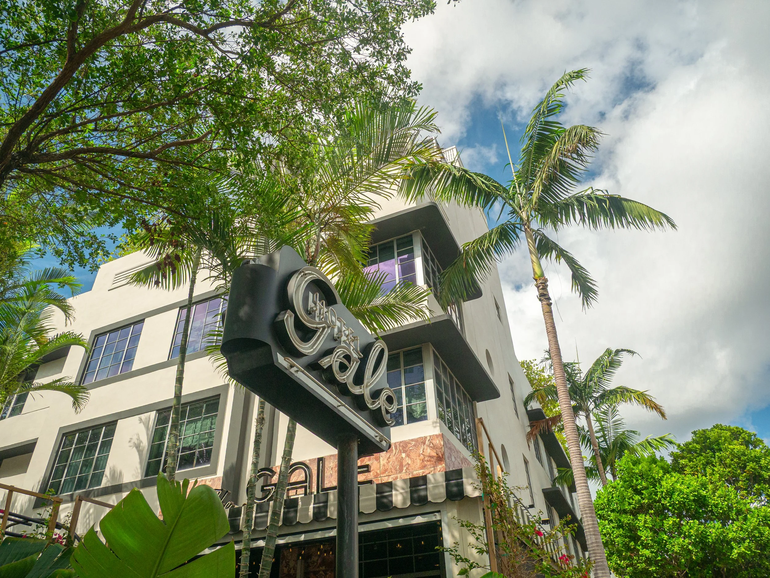 Modern Miami condo building exterior with tropical landscaping, architectural photography