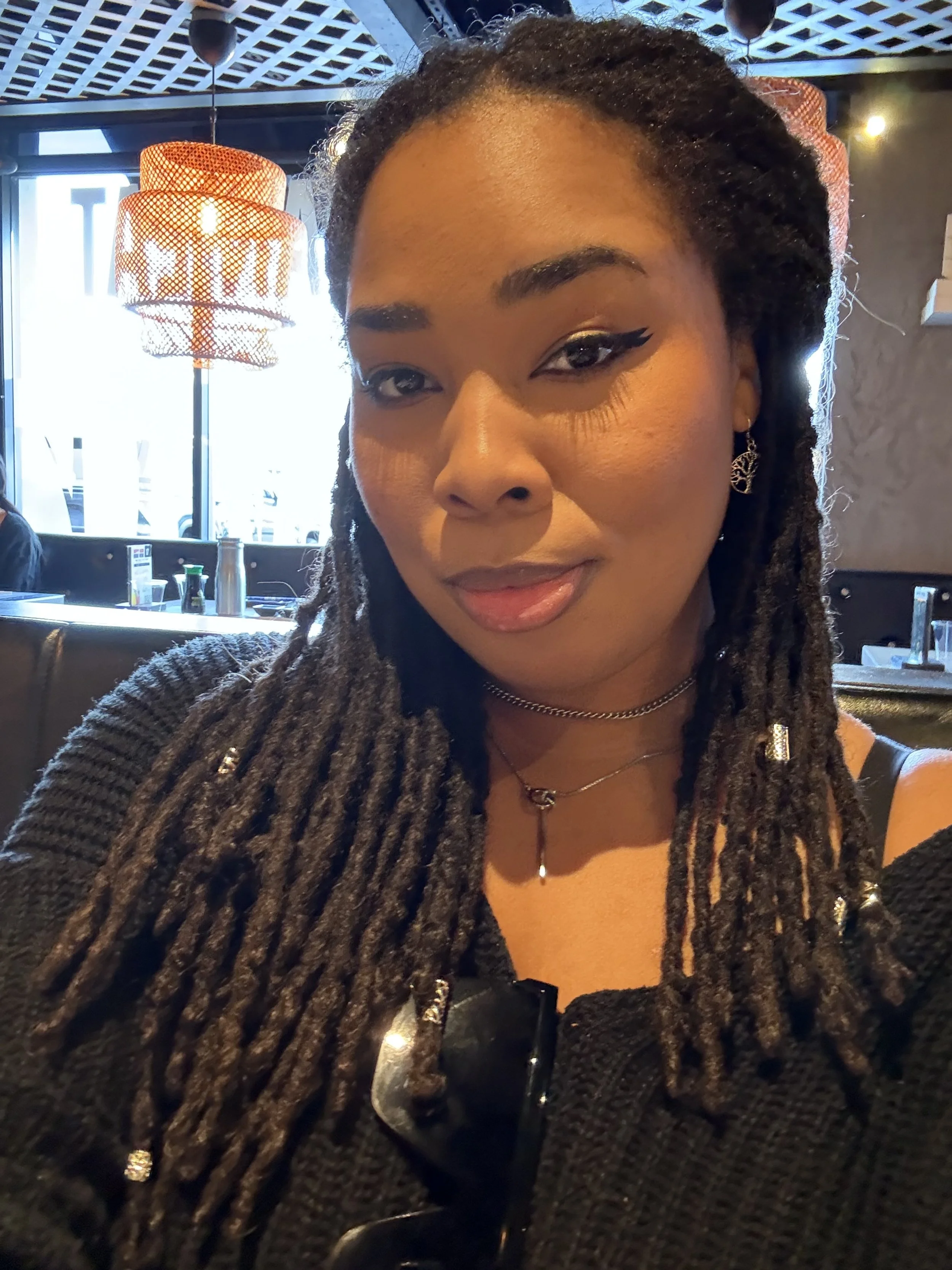 Chelsea Gayden, fiction author, smiling softly in a black sweater.