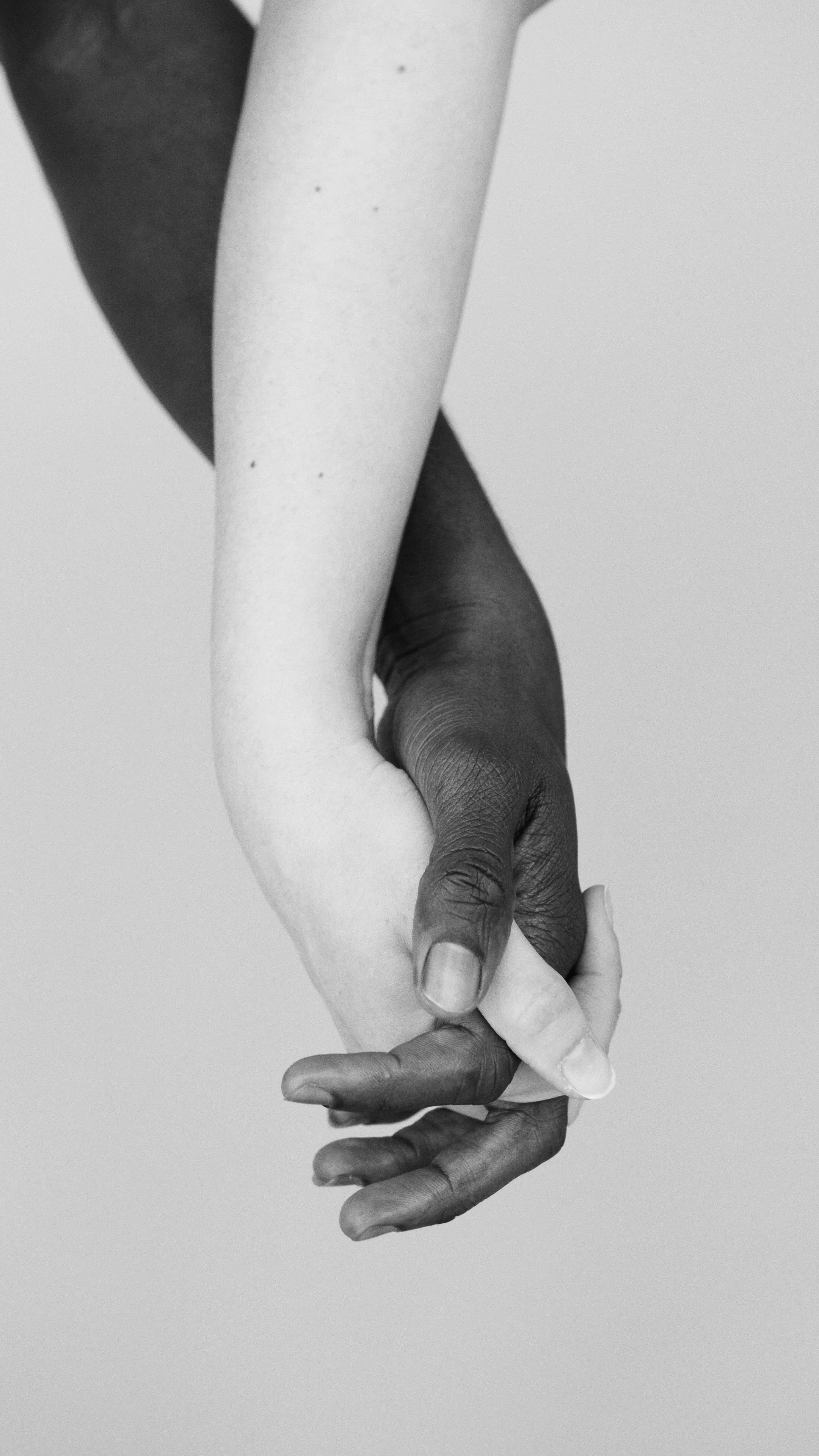 A biracial couple, holding each other in a gentle grasp.