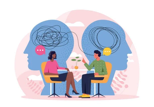 Illustration of two people in therapy, with large overlapping heads showing tangled lines representing mental health conversations, one woman and one man, sitting in chairs across from each other, exchanging dialogue.