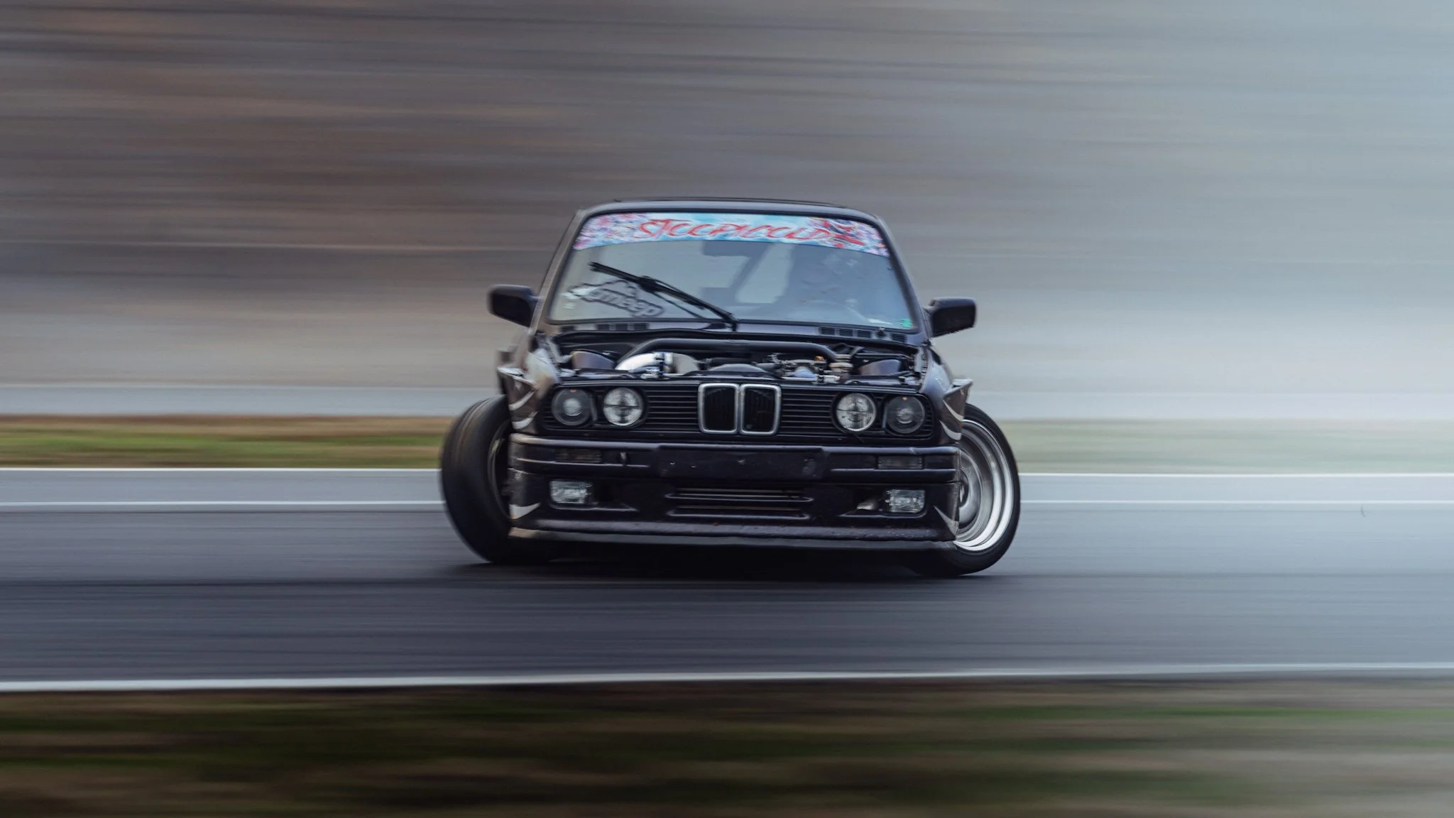 dark purple bmw e30 drifting at stoopicold motion blur
