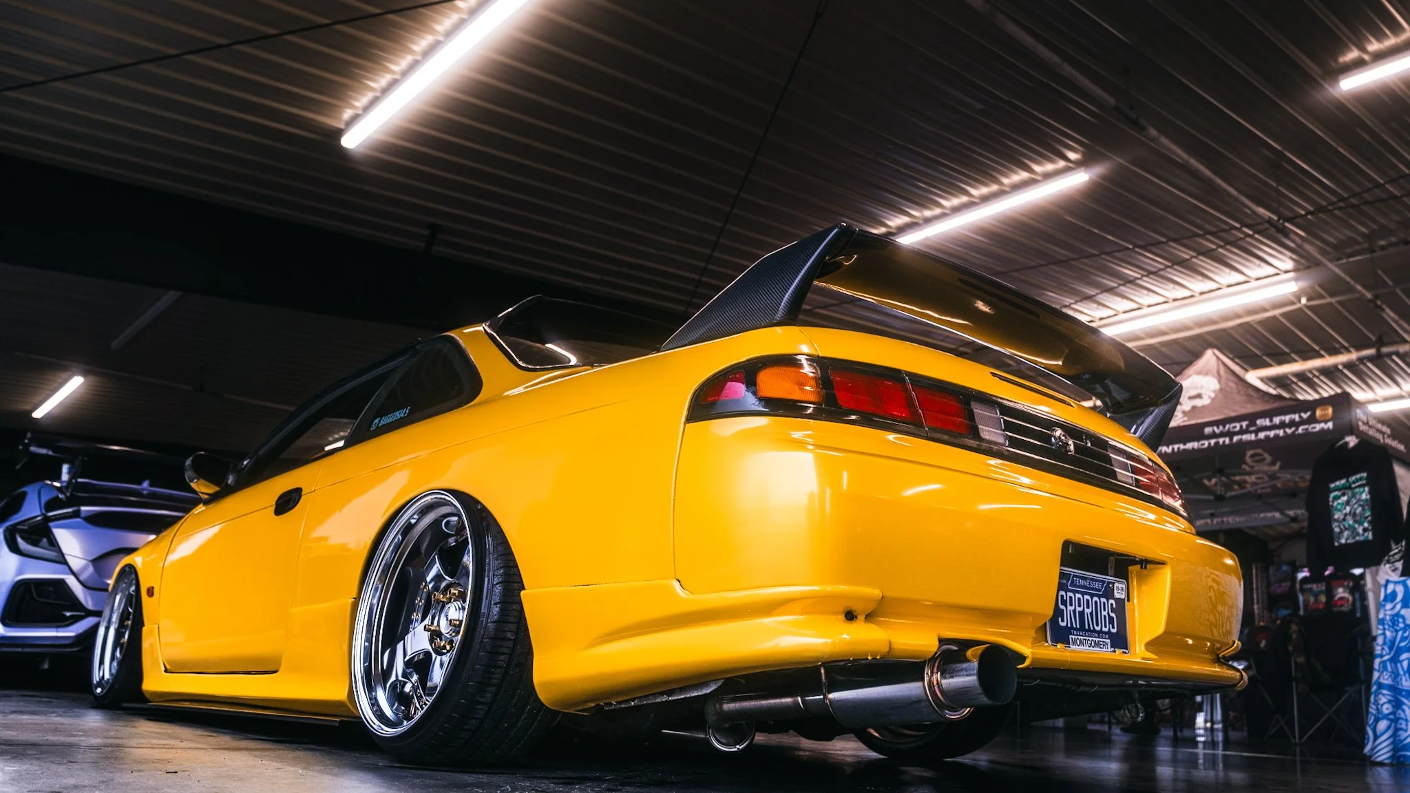 rear quarter shot of yellow Nissan S14.5 at stoopicold