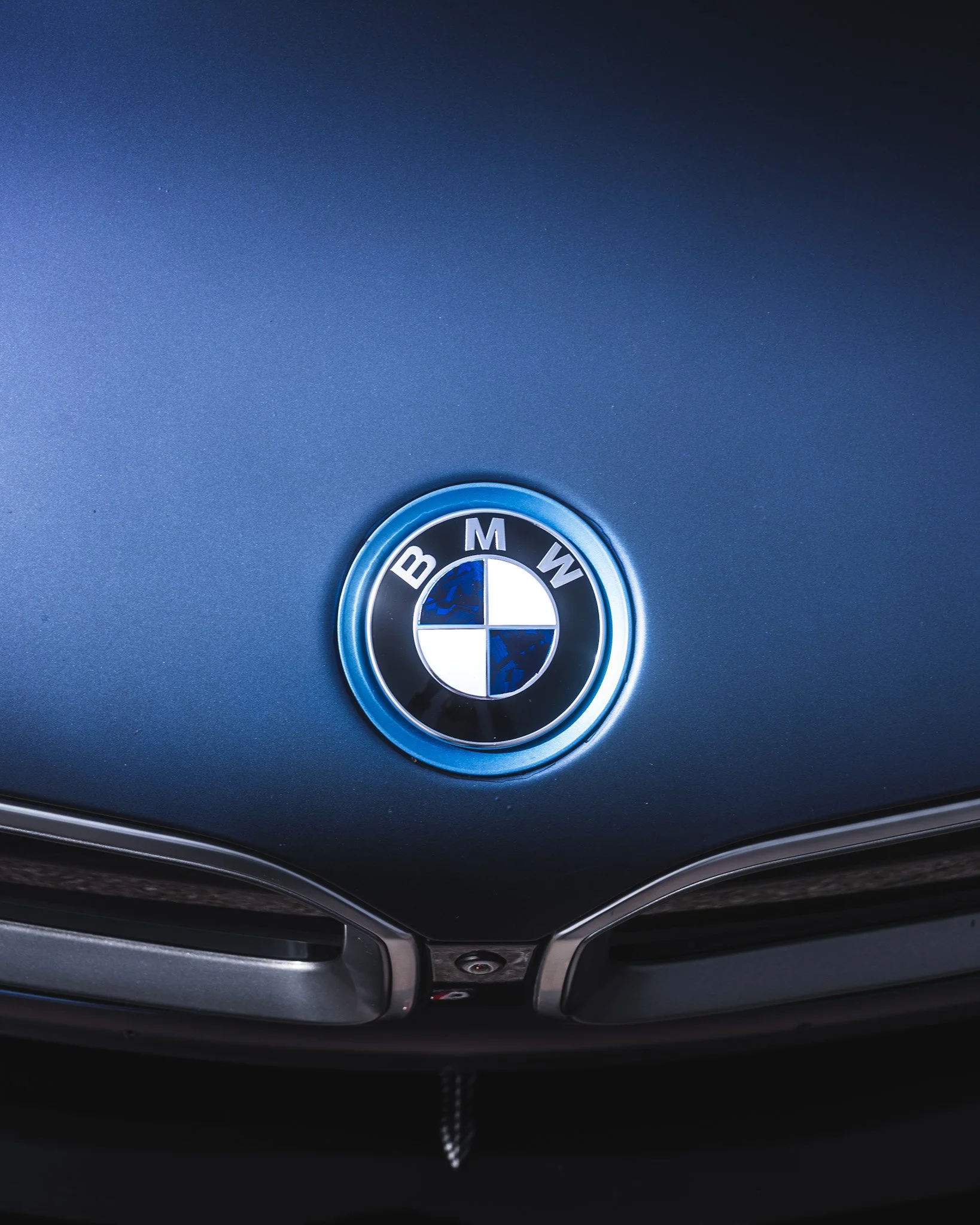 Close-up of a BMW car logo on the hood of the vehicle.
