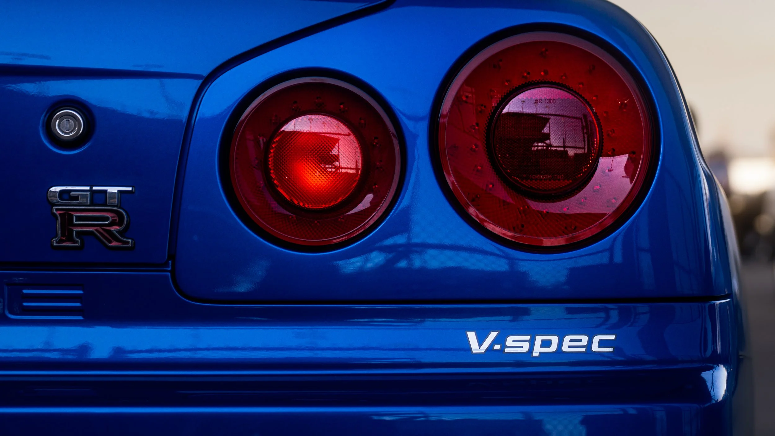 Rear taillight shot of a blue Nissan Skyline R34 V-spec