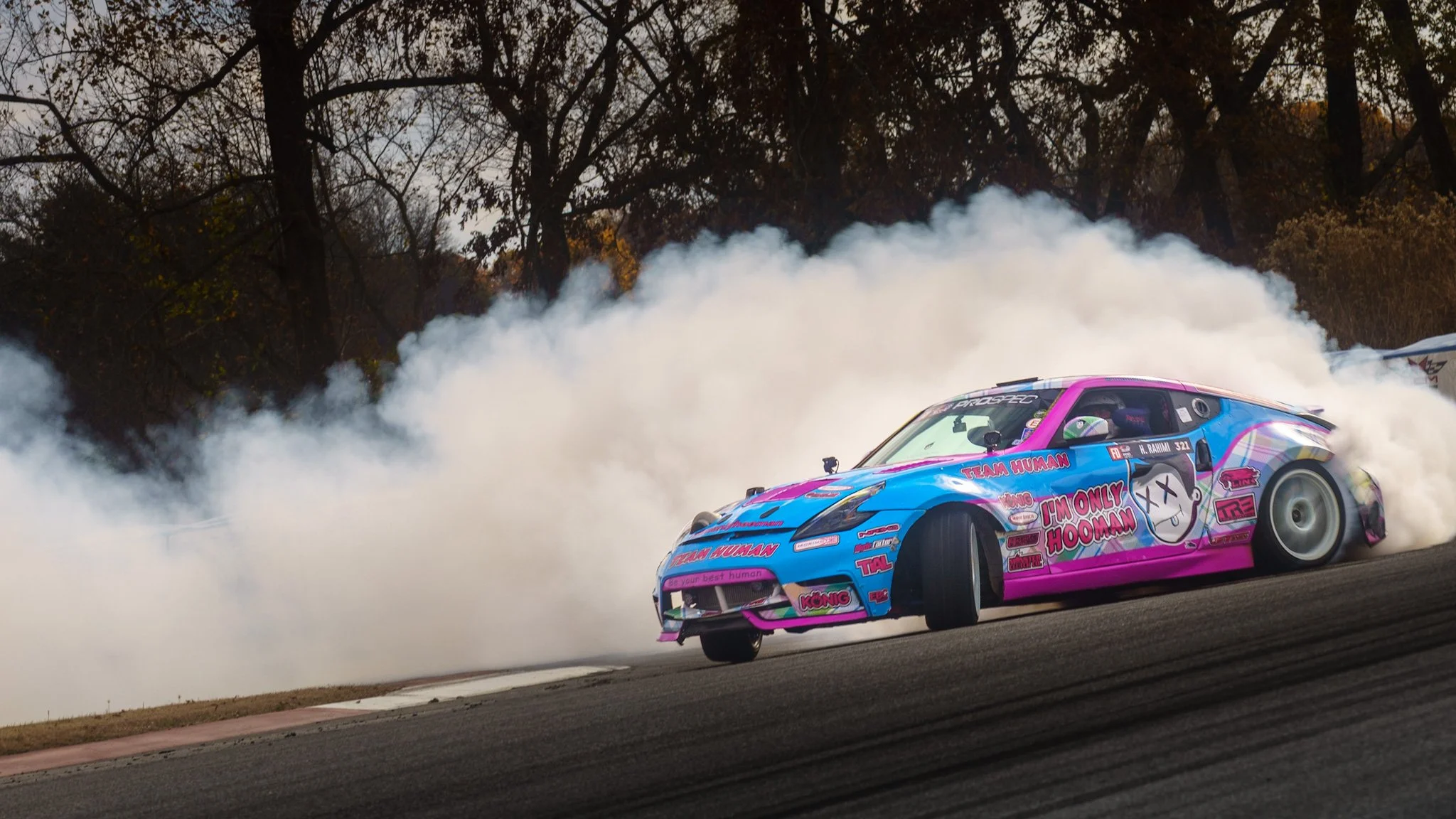 high speed action shot of IAMHOOMAN drifting in his LS swapped 370z at NCM Motorsports Park in Bowling Green Kentucky throwing up lots of tire smoke