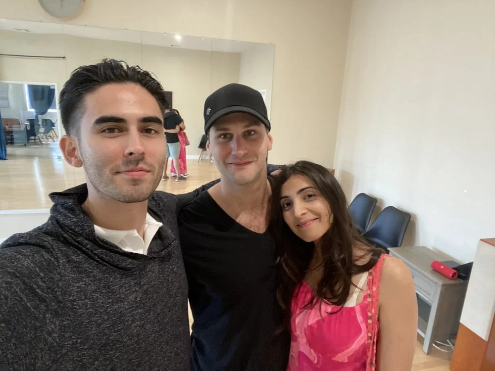 Richard, a San Francisco-based wedding dance instructor, smiling and taking a selfie in a dance studio with one of his wedding dance couples.