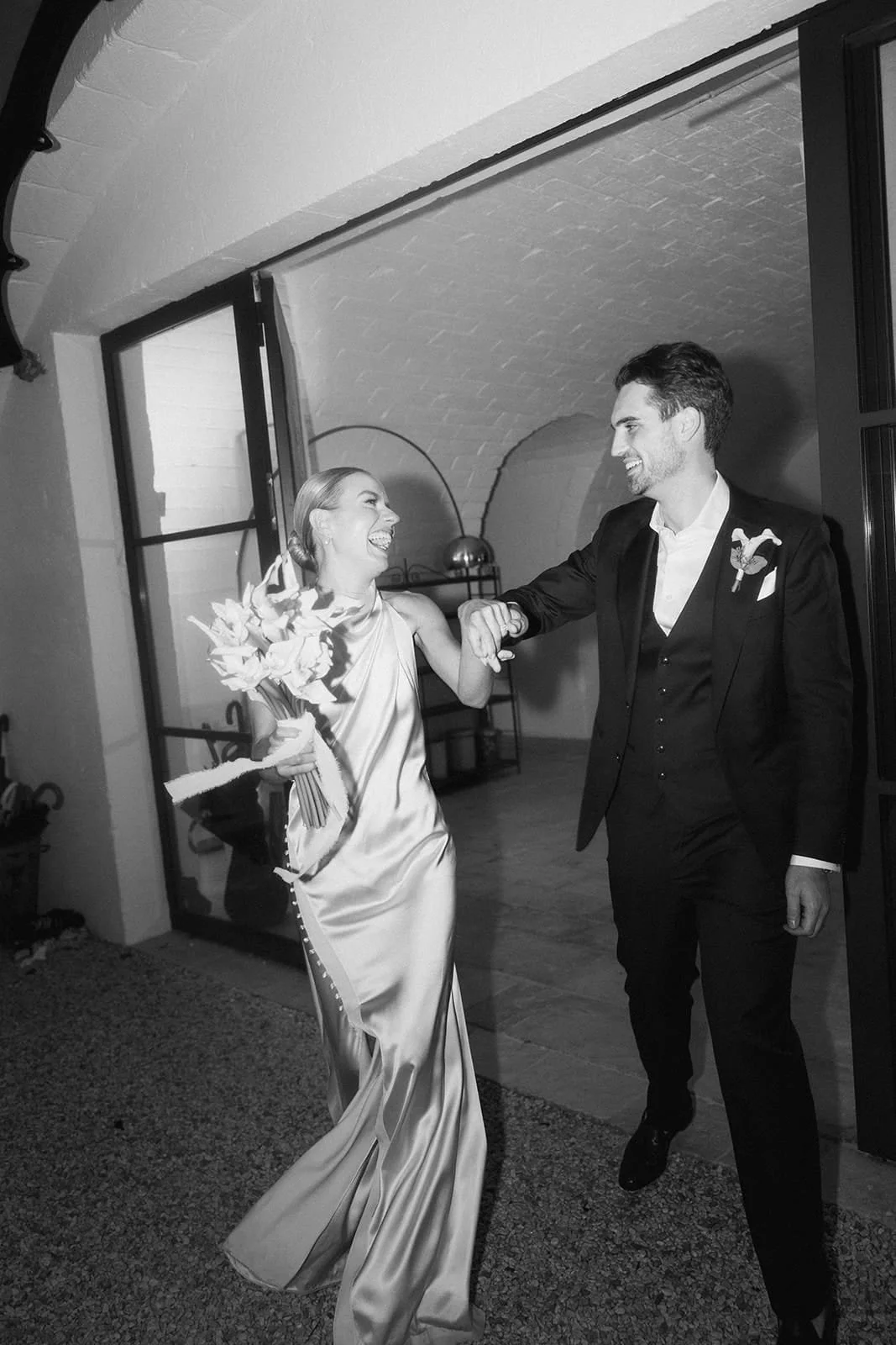 A newly married couple, smiling and dancing together at their wedding.