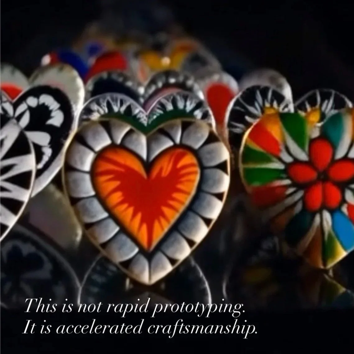 Colorful painted stone and metal hearts and flowers with the caption "This is not rapid prototyping. It is accelerated craftsmanship."
