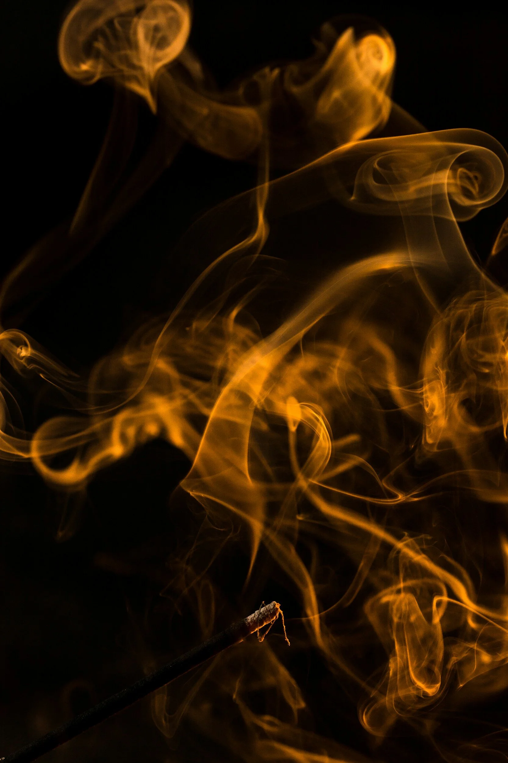striking orange incense smoke on a dark black background representing space for clergy and seminarian therapy in San Francisco and Marin. Depth-oriented counseling approach for pastors, priests, rabbis, MDiv students and religious leaders and trauma