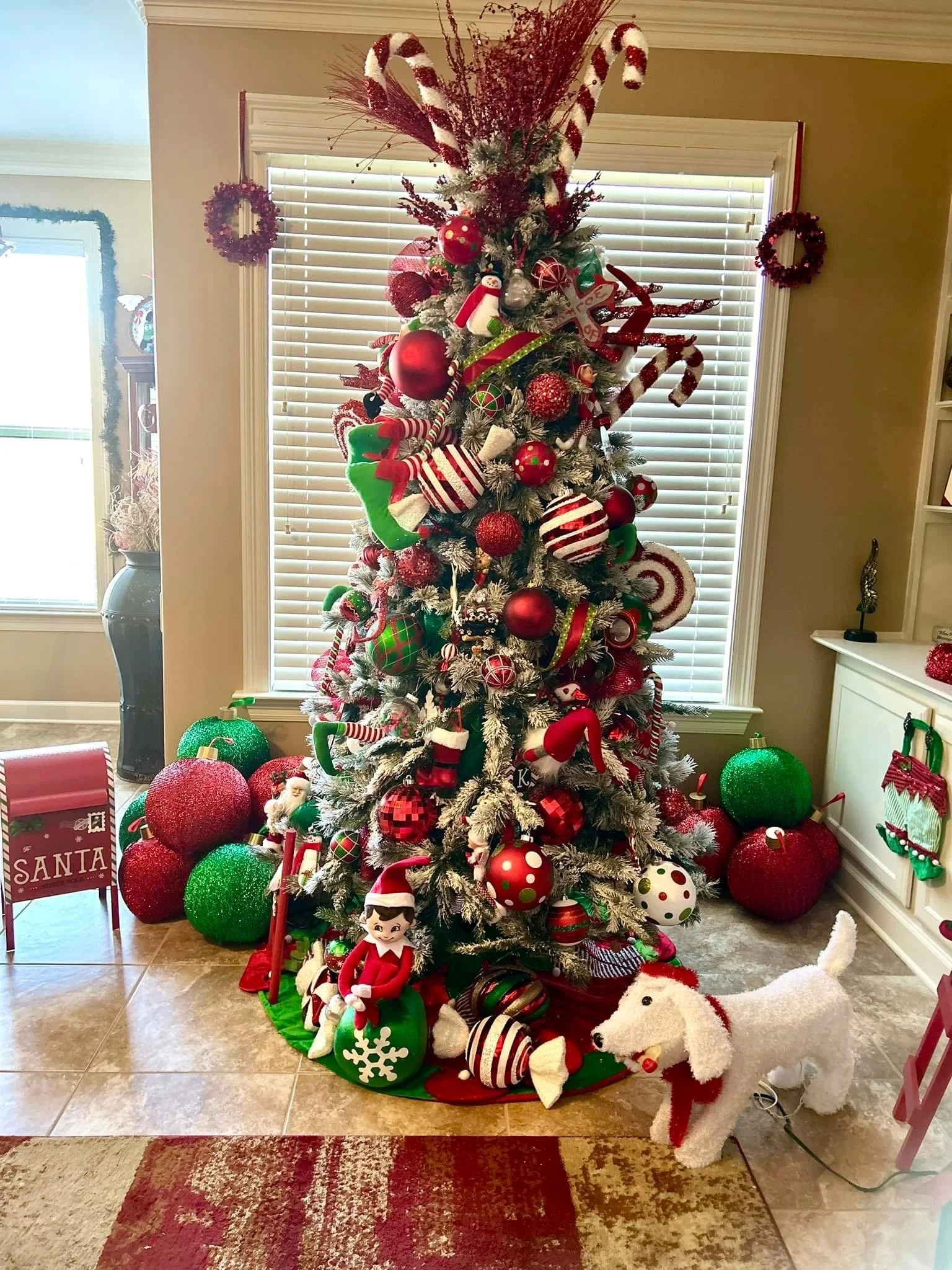 Decorated Christmas tree with ornaments, candy canes, and festive decorations, surrounded by gift decorations and holiday plush toys.