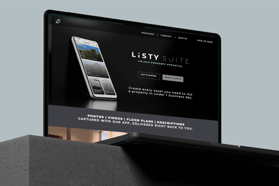 MacBook displaying the website for Listy Suite, a property listing management service, with menu options and a smartphone image on the screen.