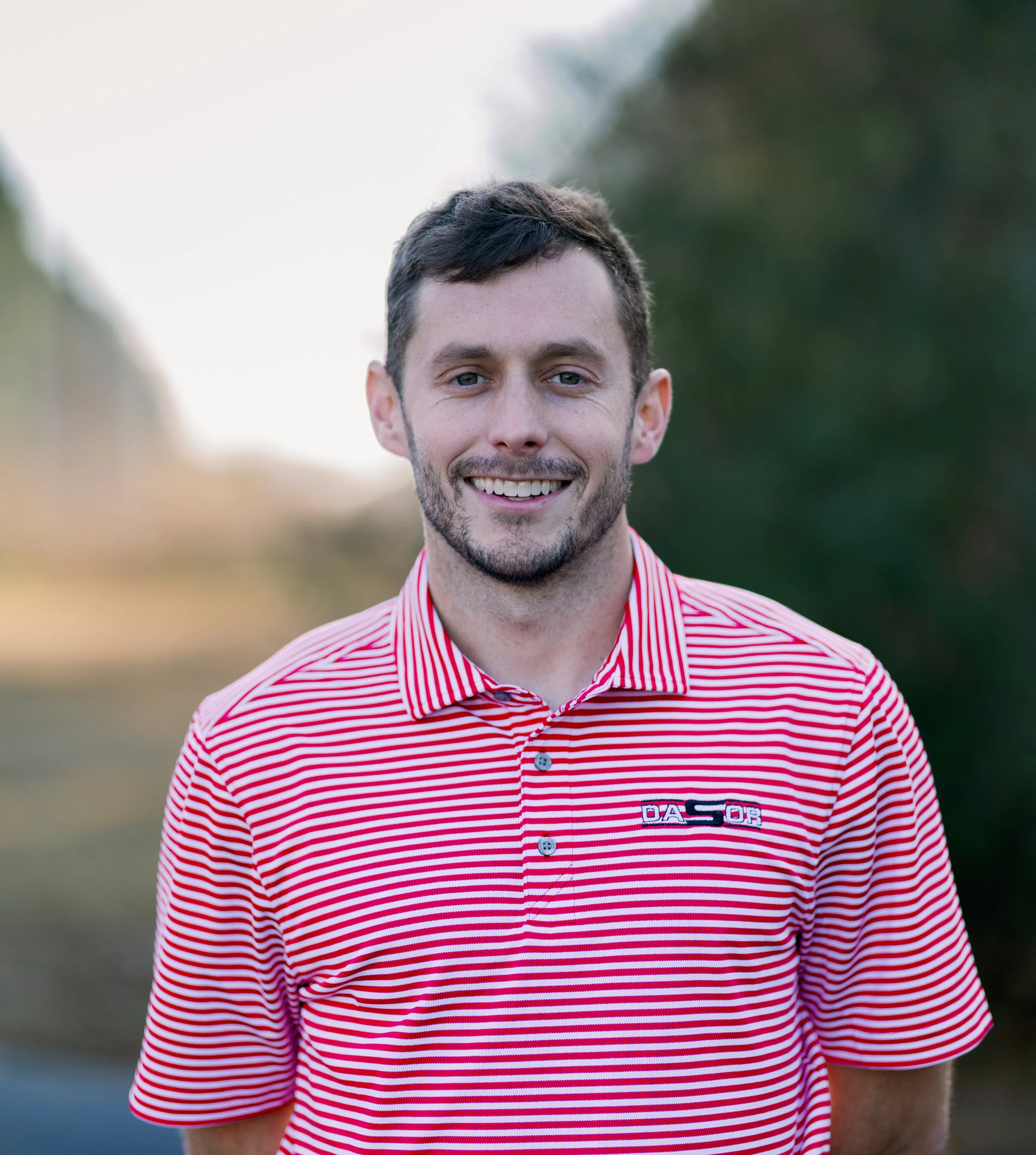 Woman sitting on a bench, writing in a notebook, with abstract artwork leaning against the wall beside her.