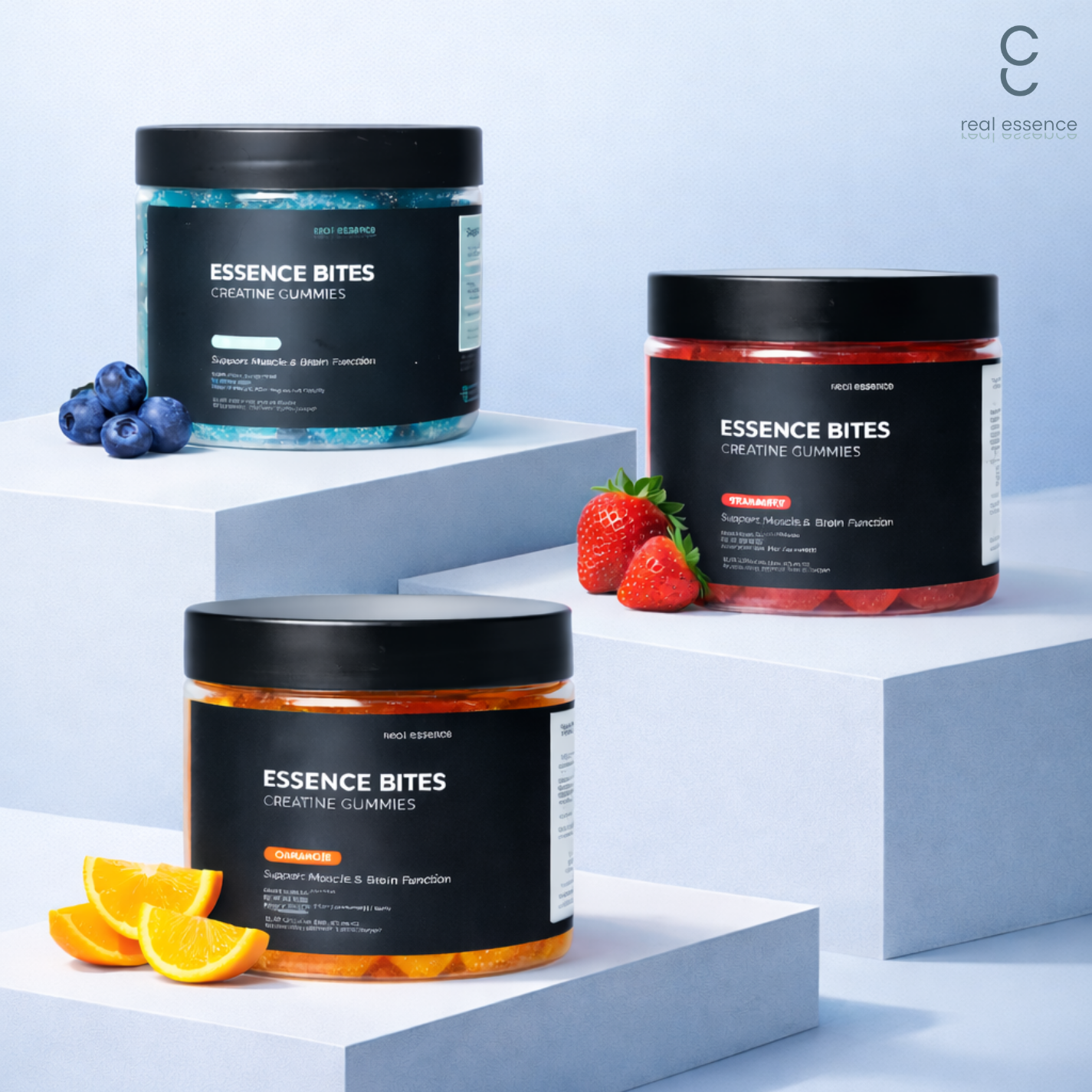 Three containers of Essence Bites creatine gummies in different flavors, with blueberries, strawberries, and orange slices nearby, against a light blue background.