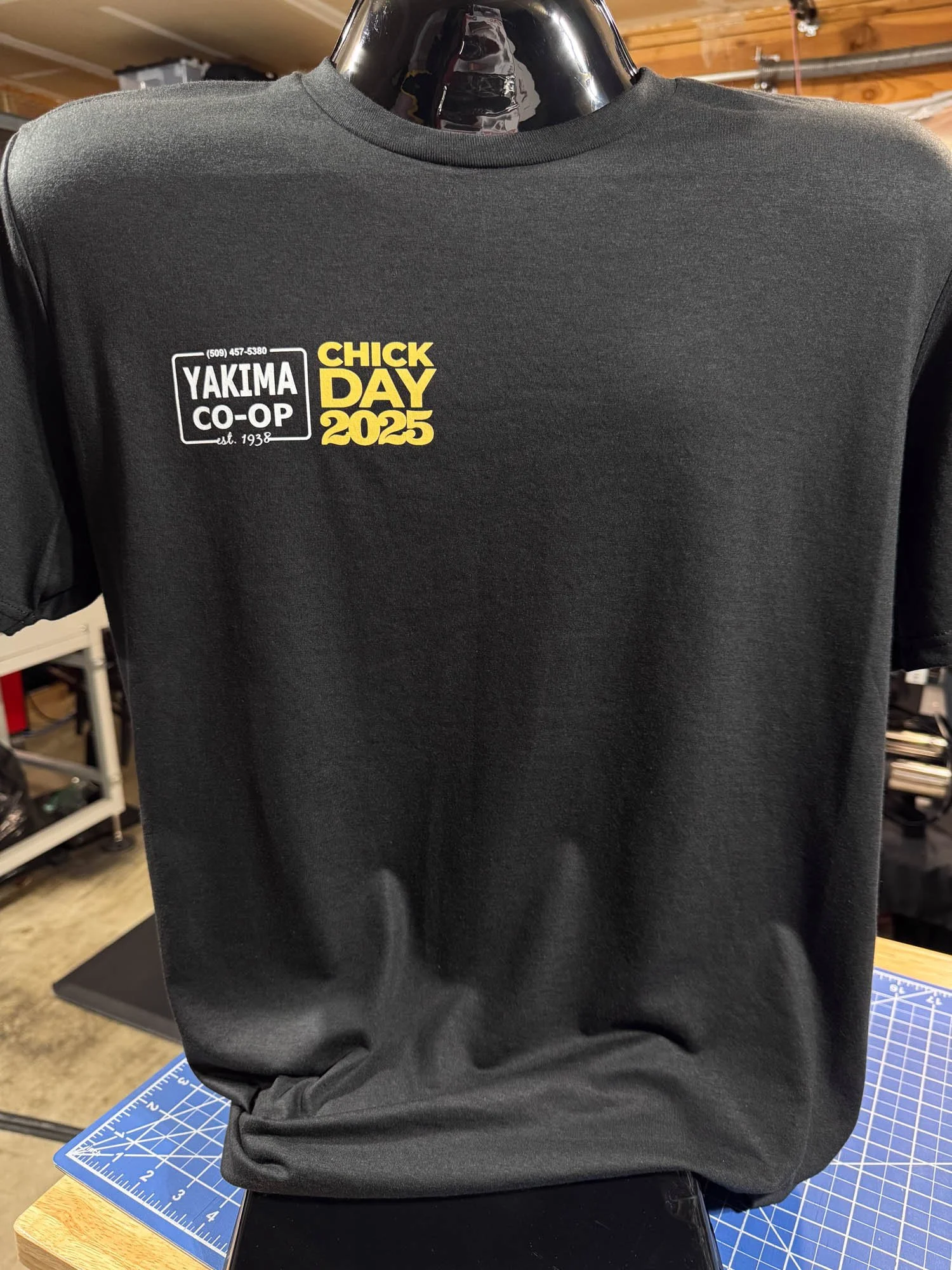 Black t-shirt with yellow and white printed logos for Yakima Co-op and Chick Day 2025.