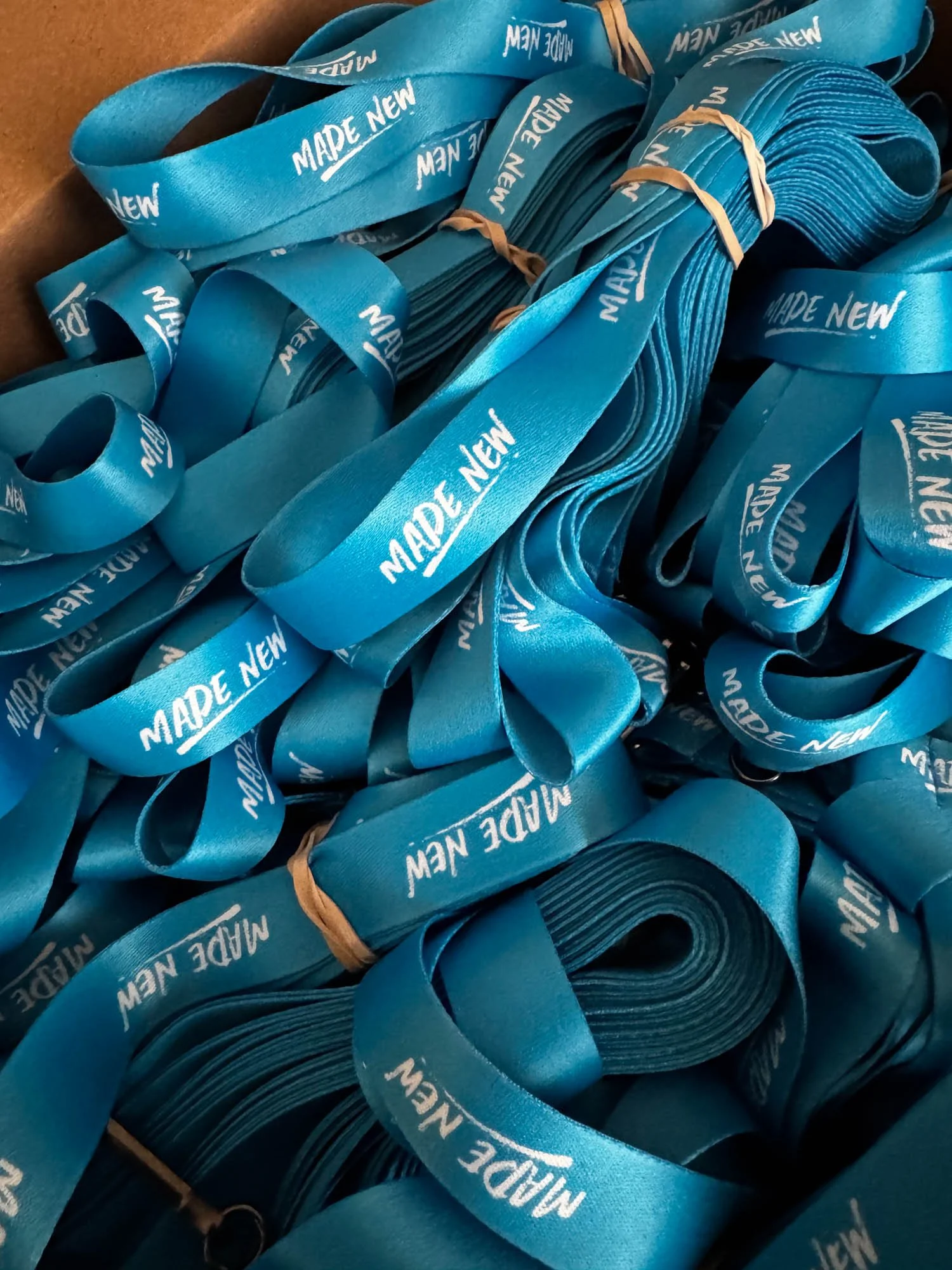 Bundles of blue ribbons with the words 'MADE NEW' printed repeatedly in white.
