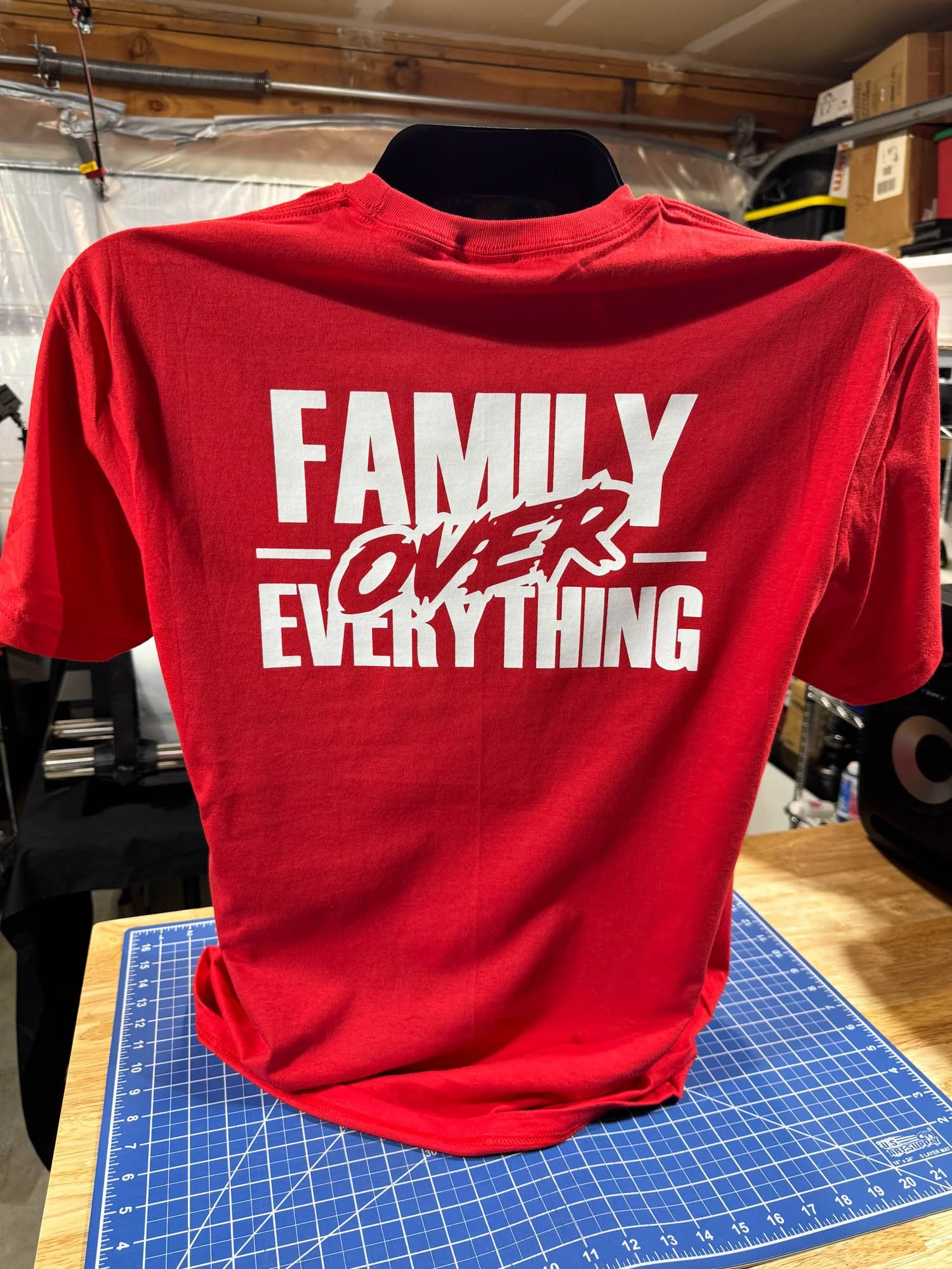 Red T-shirt with the phrase 'FAMILY OVER EVERYTHING' in bold white letters and an animated word 'OVER' with a lightning bolt design.