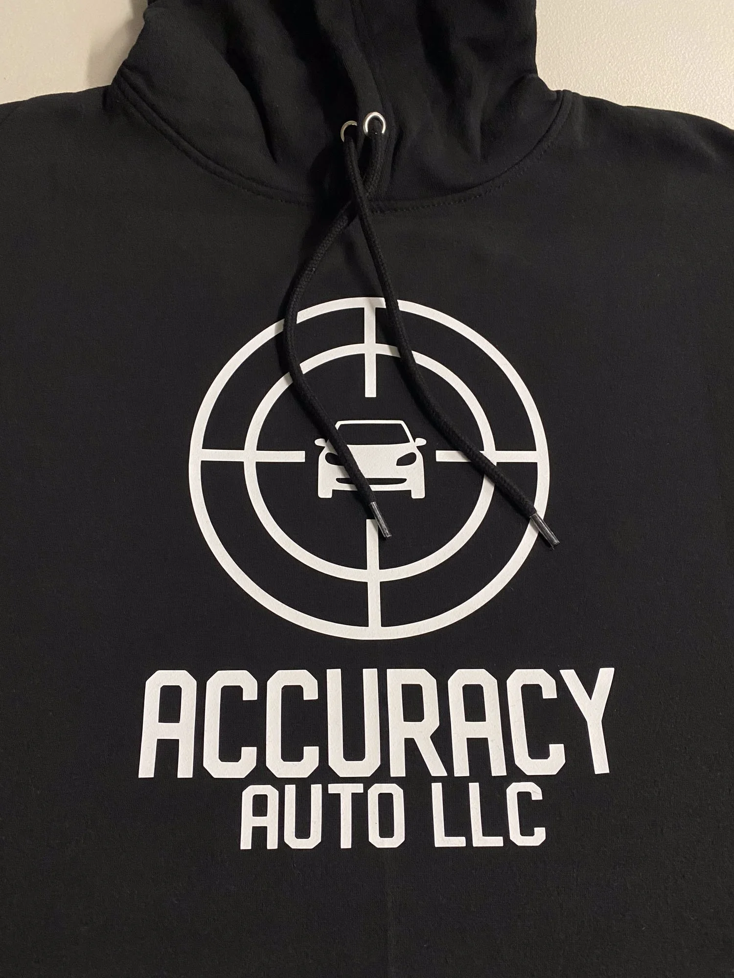 Black hoodie with a white graphic of a car in the crosshairs and the text "ACCURACY AUTO LLC" below.
