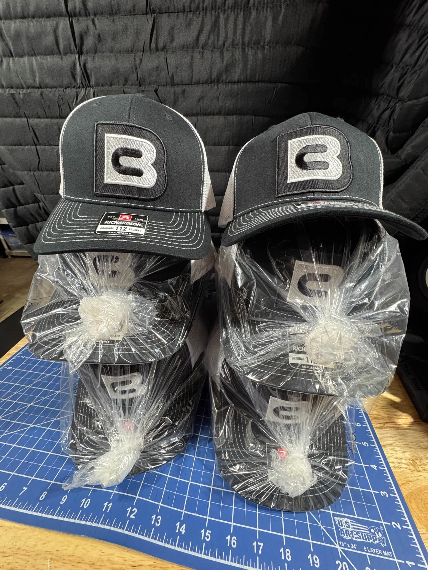 Two stacks of black and white Richardson racing caps with a large 