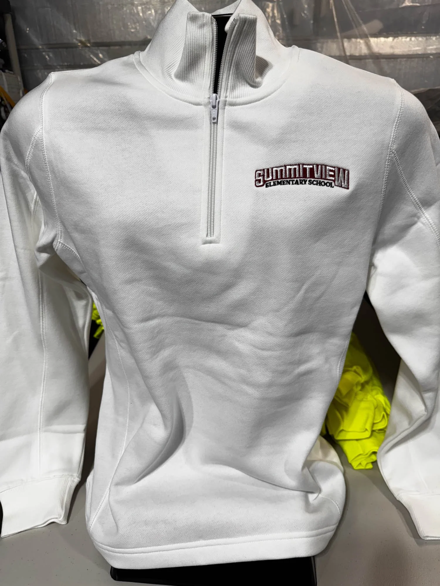 White sweatshirt with a quarter-zip collar and embroidered logo reading "Summitview Elementary School" on the chest.