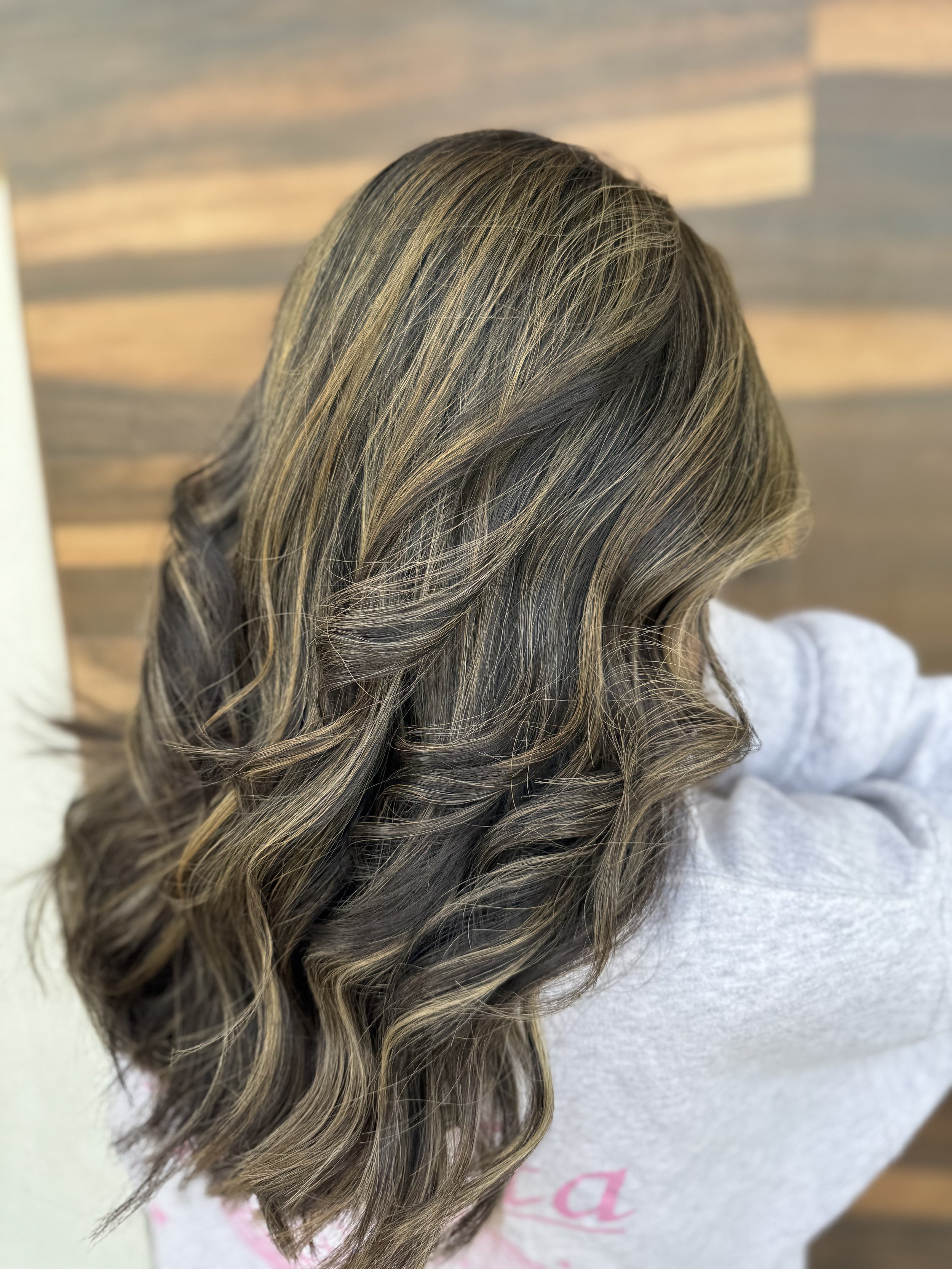 A woman with medium-length, wavy hair with blonde highlights.