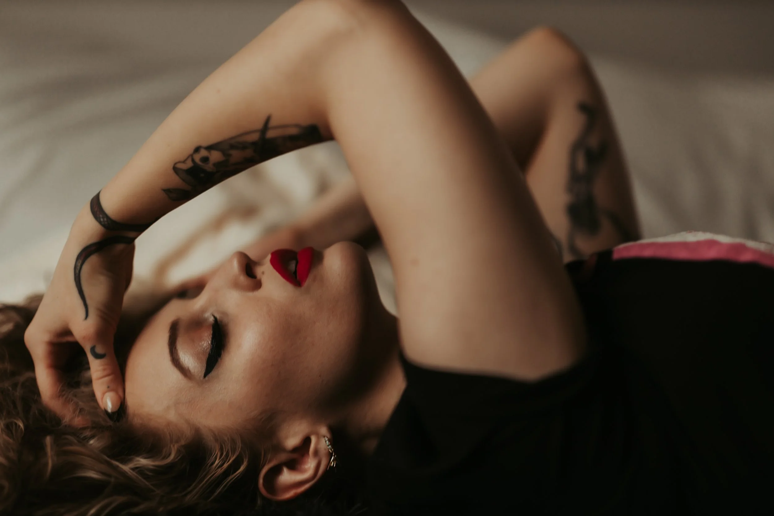 Close-up boudoir portrait of a woman looking radiant and confident, representing the magical and positive experience at Dark Room Boudoir.