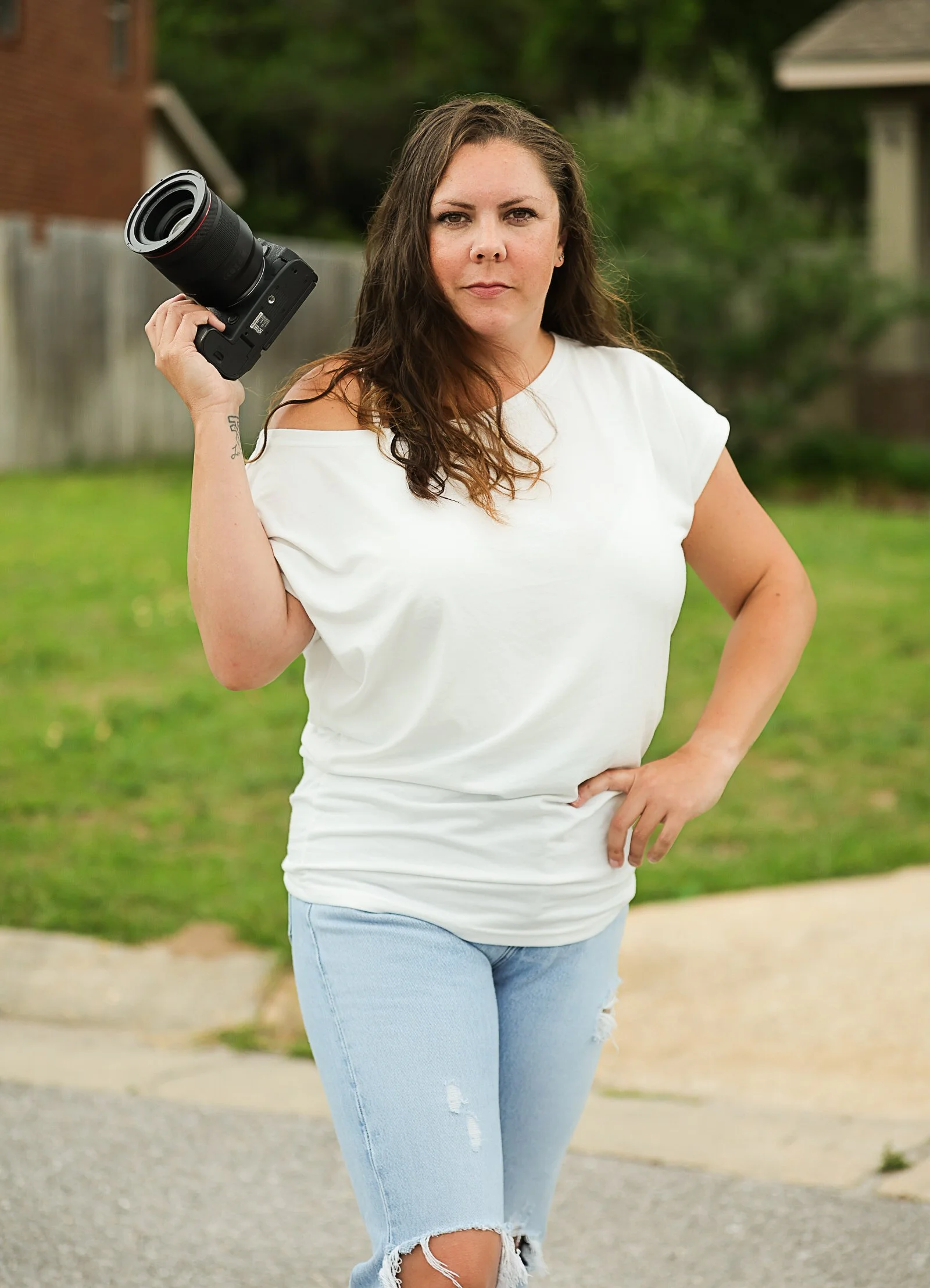 Madison Anderson, lead photographer at Dark Room Boudoir, holding a professional camera in a luxury studio setting in Gulf Breeze, Florida.