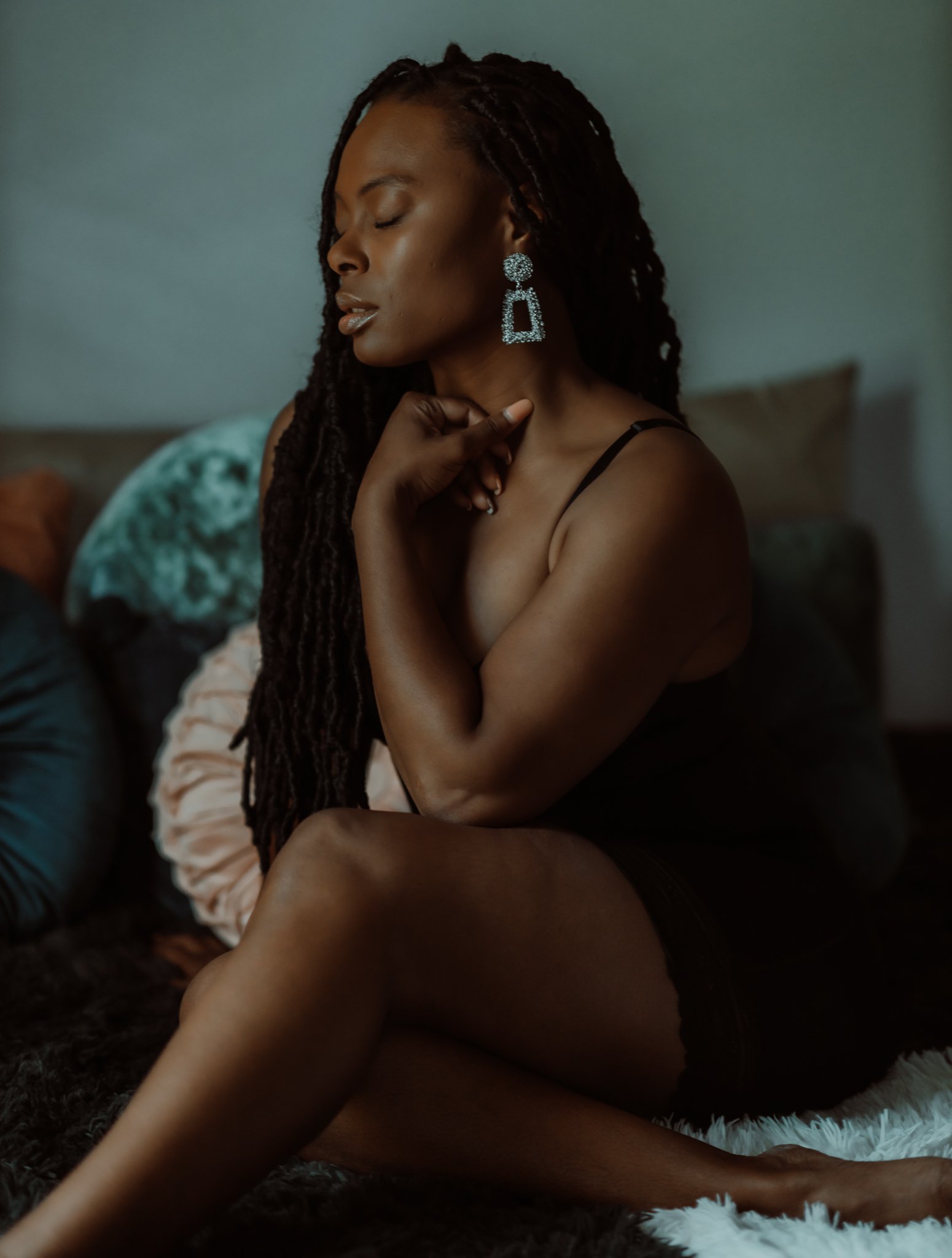 Soulful seated boudoir portrait highlighting professional hair, makeup, and wardrobe styling for a real client session.