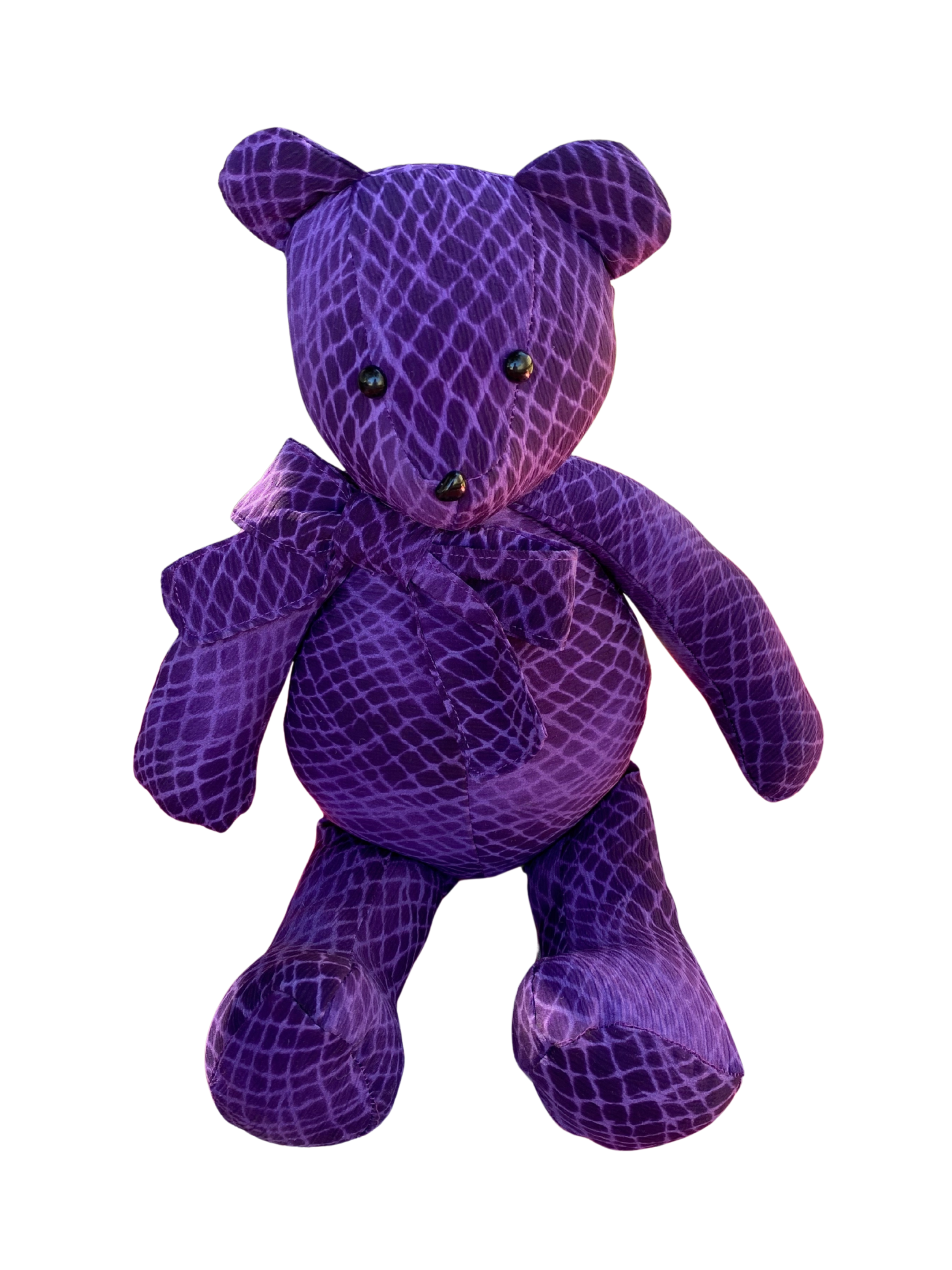 Purple teddy bear with a patterned fabric resembling a snakeskin texture, standing upright against a white background.