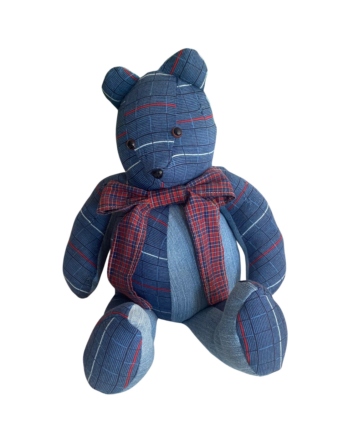 A stuffed teddy bear made of blue plaid fabric with red and white accents, wearing a matching plaid bow tie.