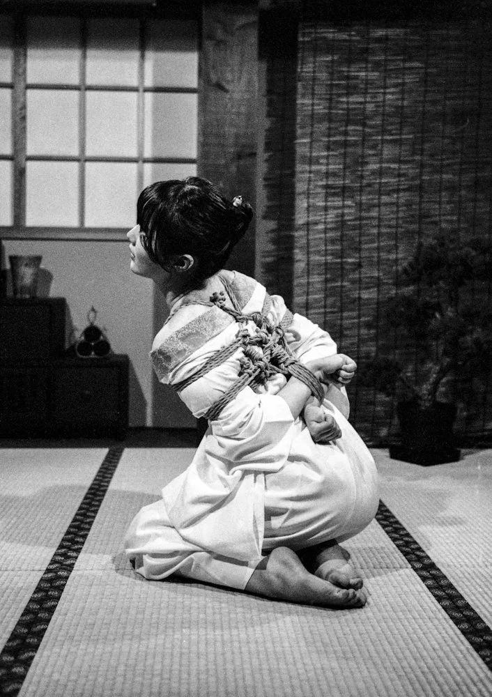 Black and white image of a Japanese lady tied in shibari.