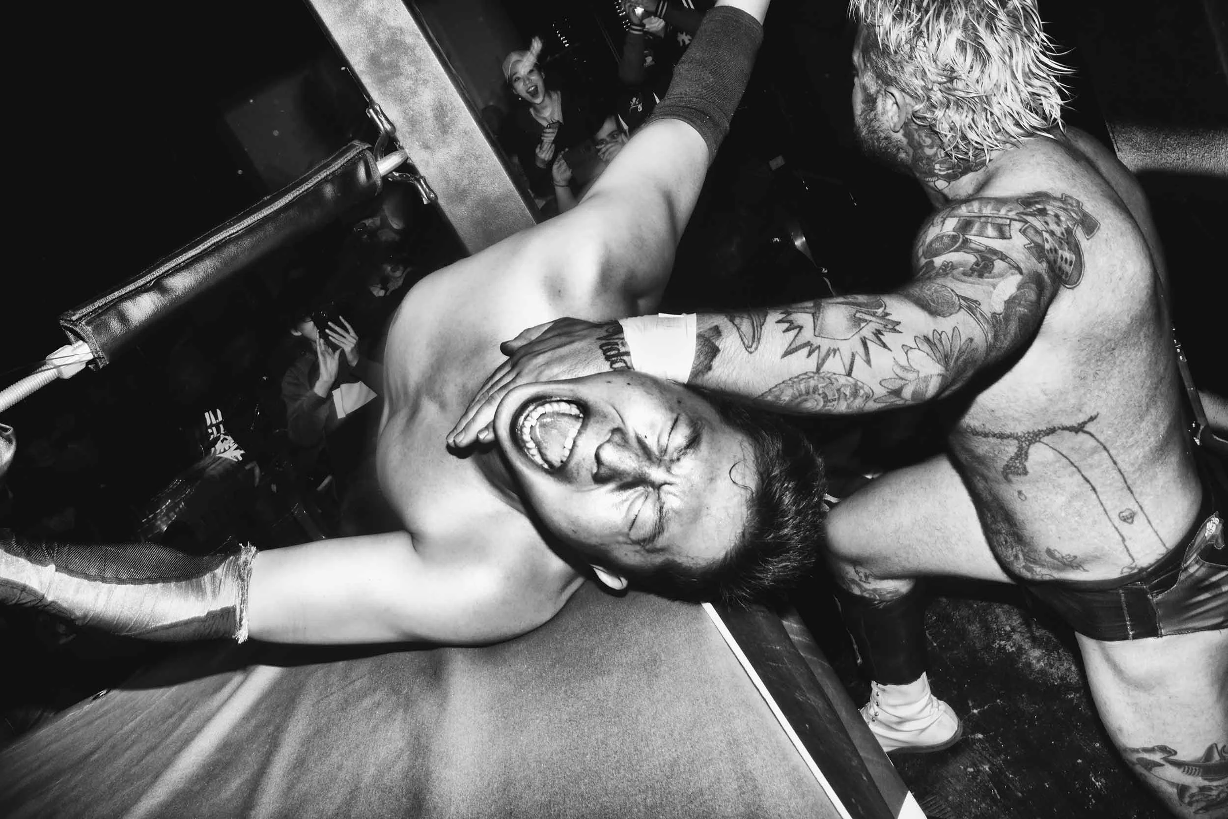 Black and white photo of Shiho struggling to get out of Zicky Dice’s submission attempt.