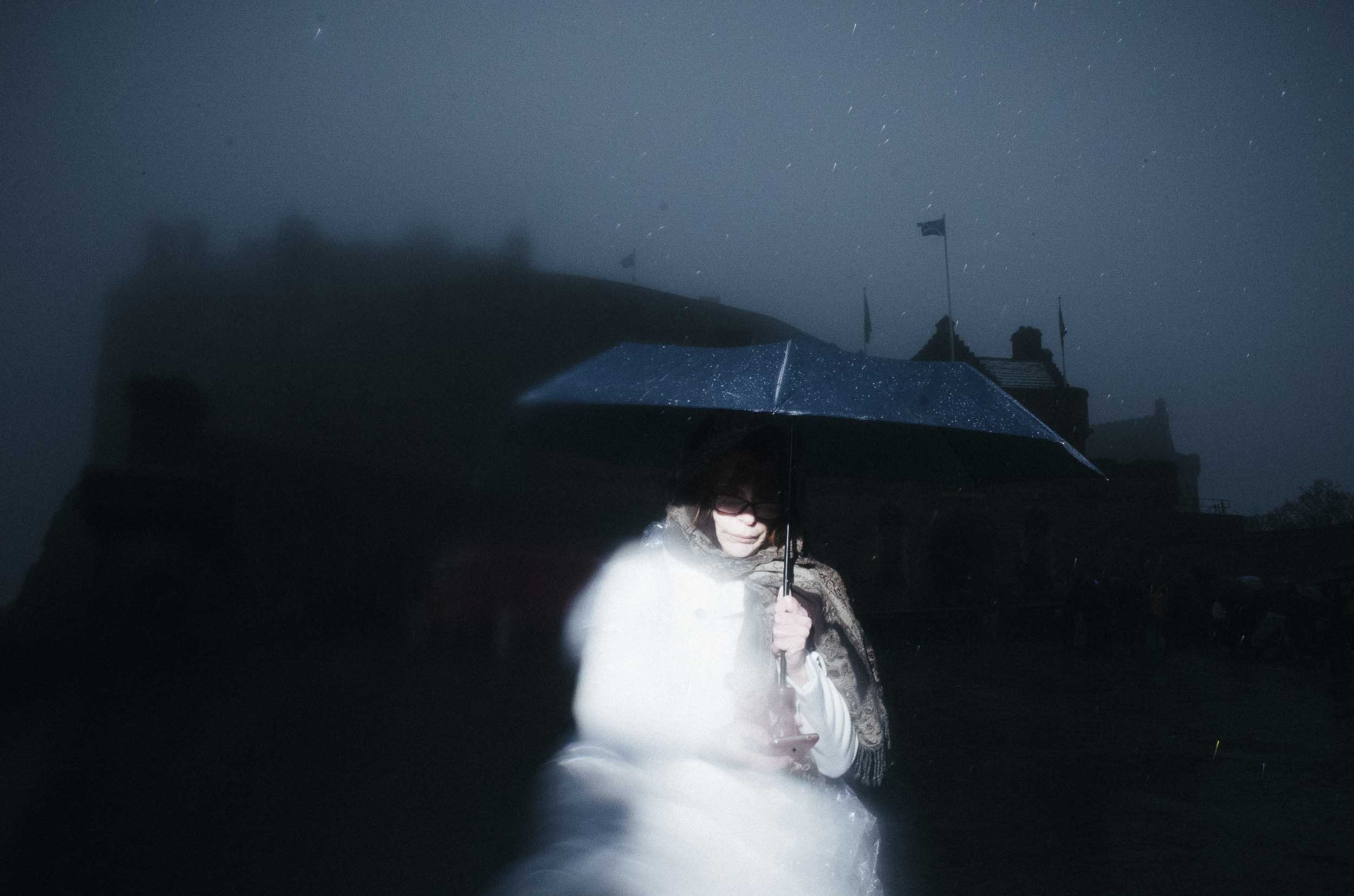 A lady holding an umbrella is walking towards the camera.