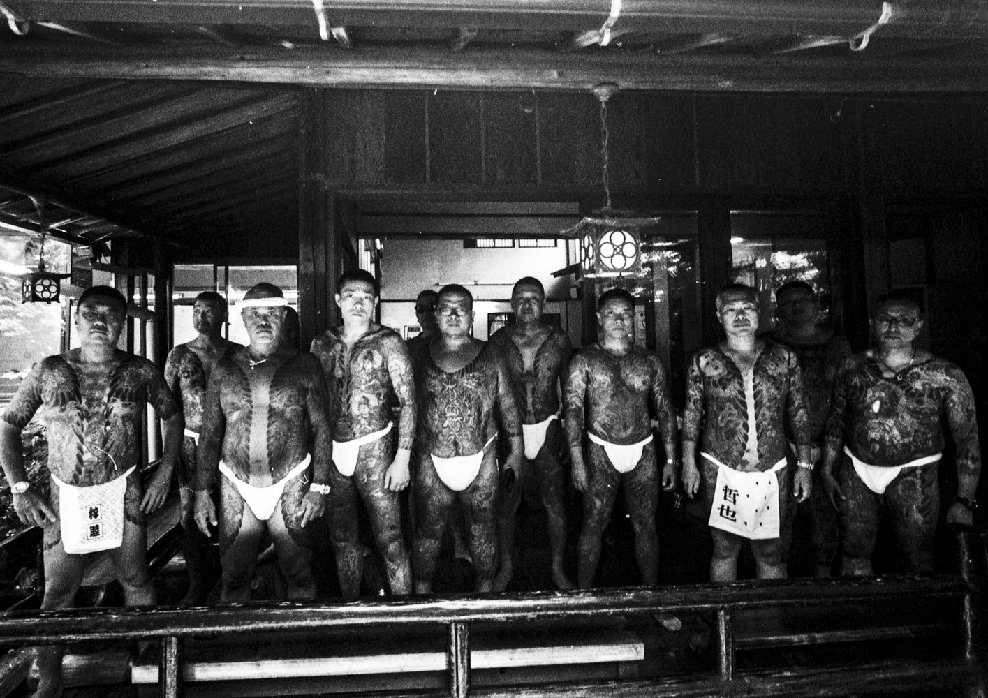 Black and white group portrait of heavily tattooed Japanese Yakuza members.