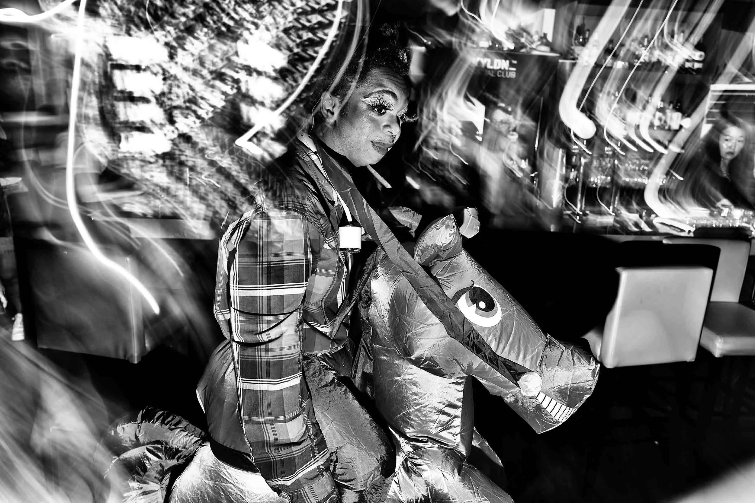 Black and white photo of someone in fancy dress as a jockey riding a horse.