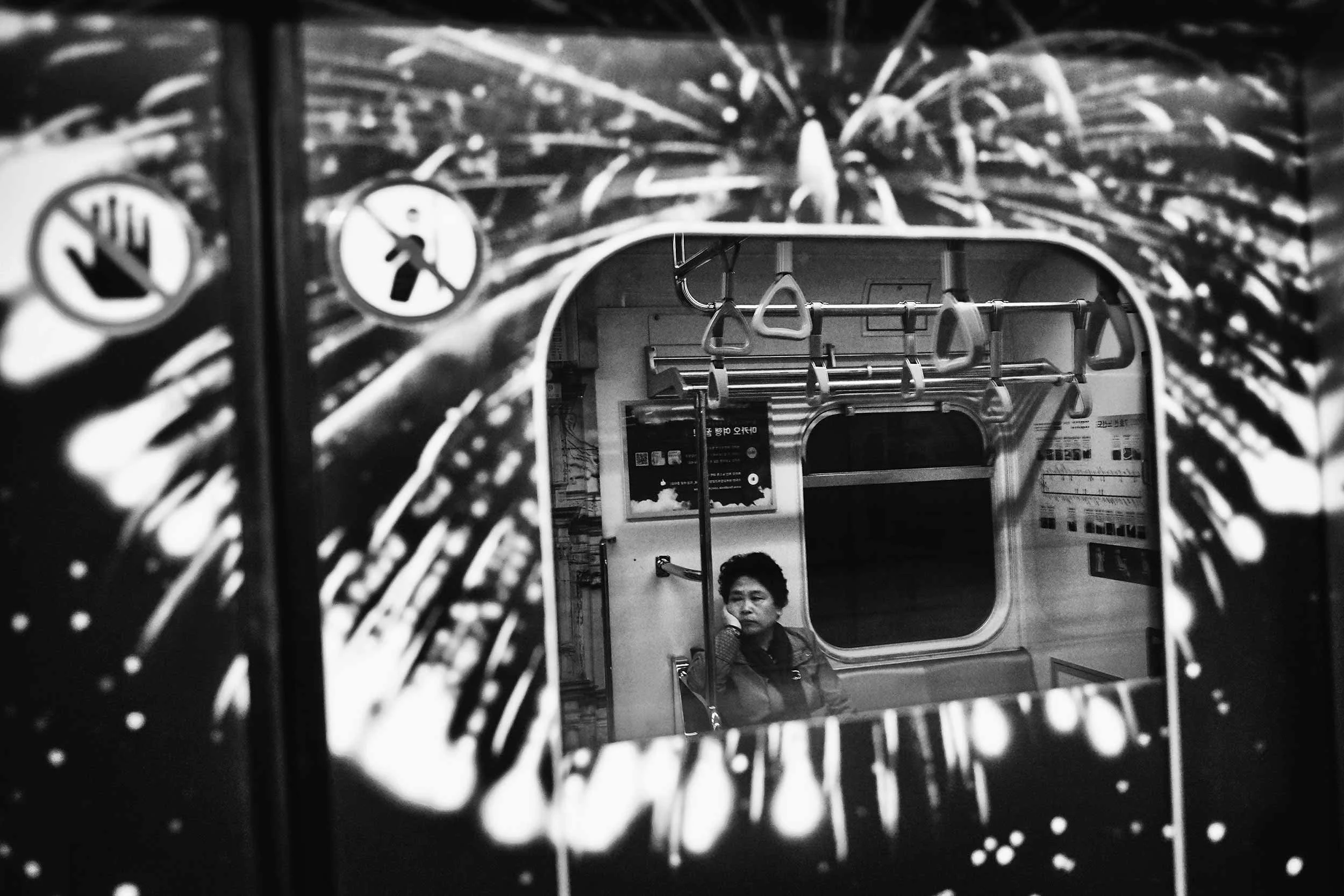 Black and white photo of inside the Seoul Metro.