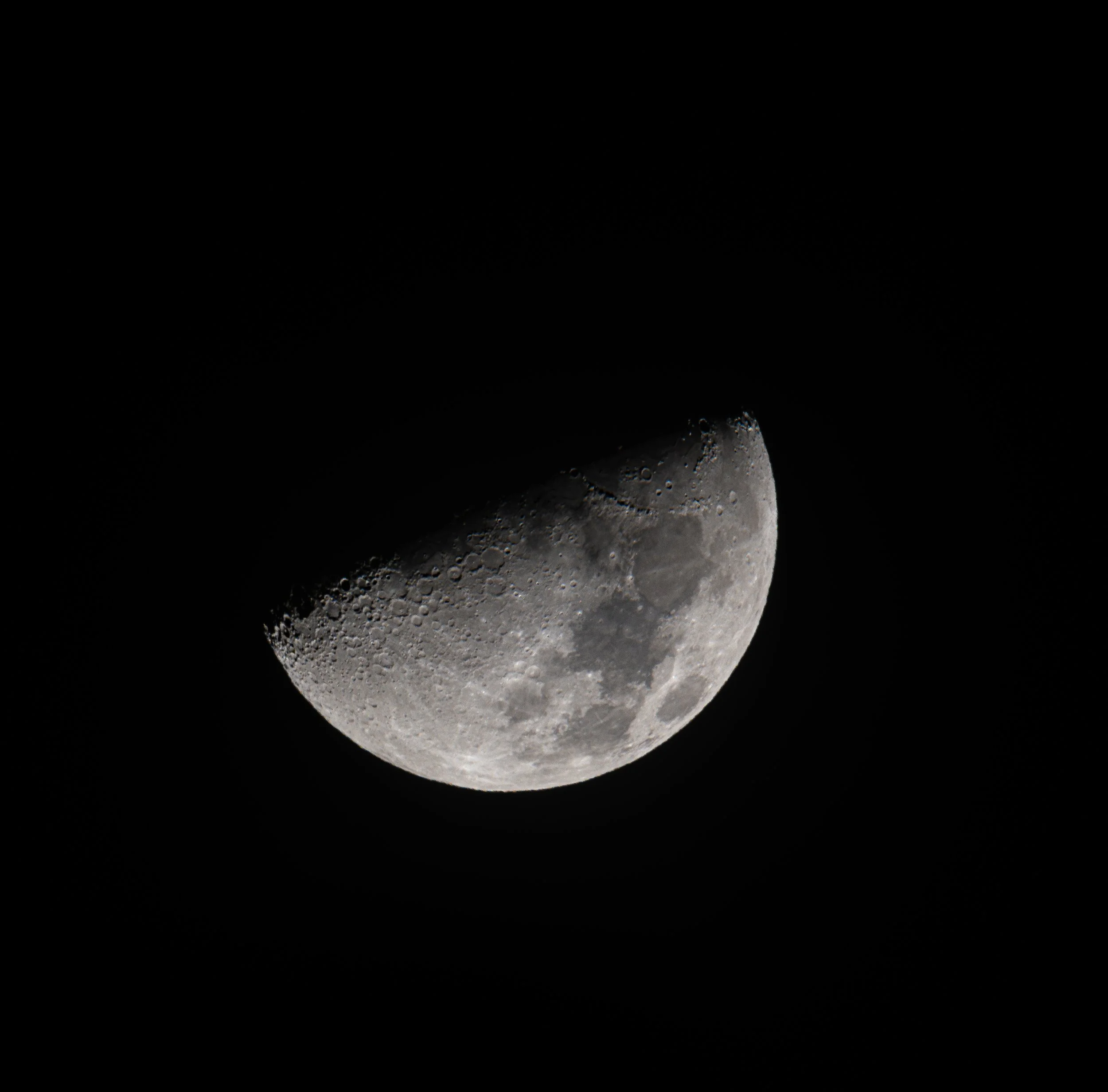 Close-up of the moon showing craters and surface details against a black sky.