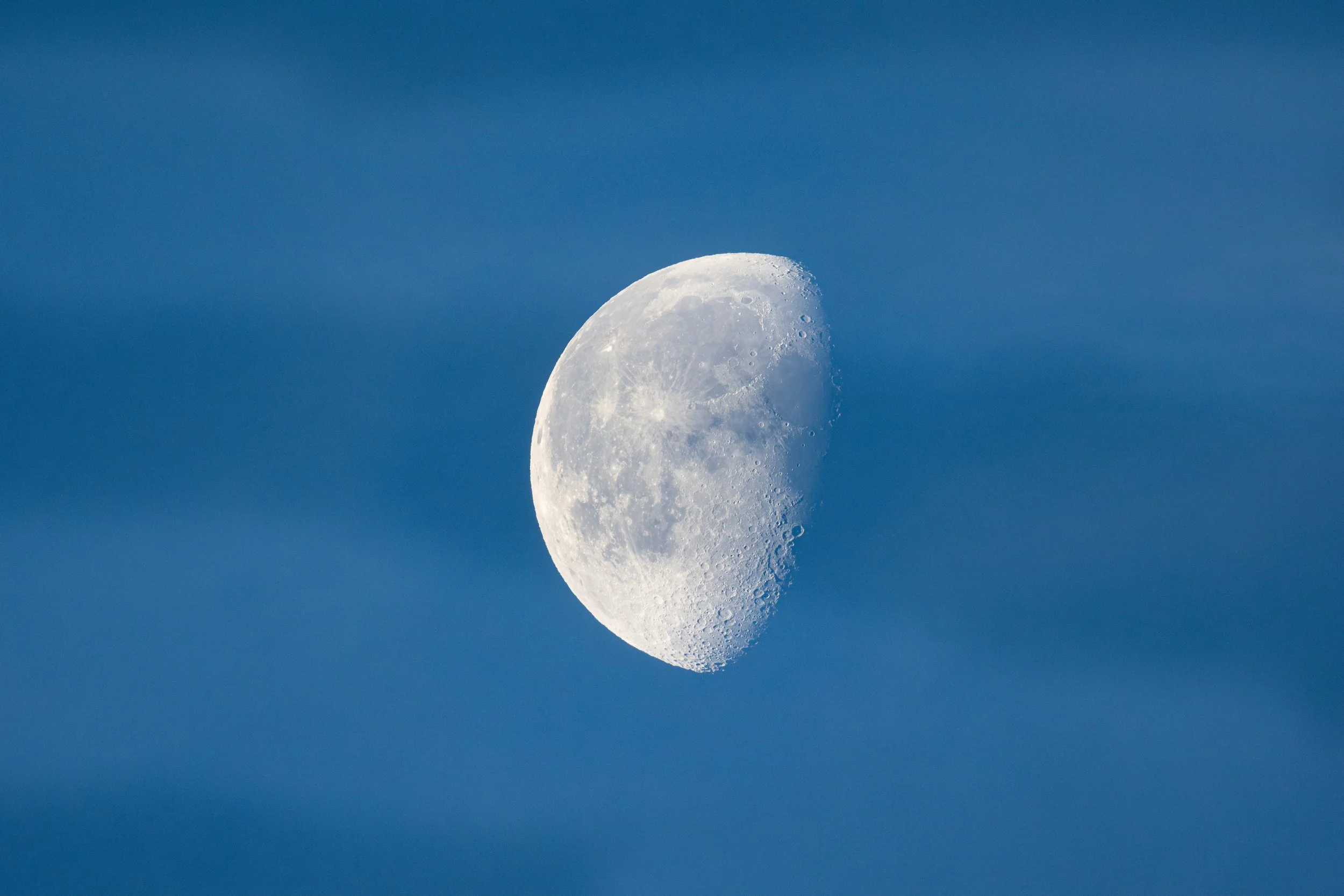 Half moon in a clear blue sky.
