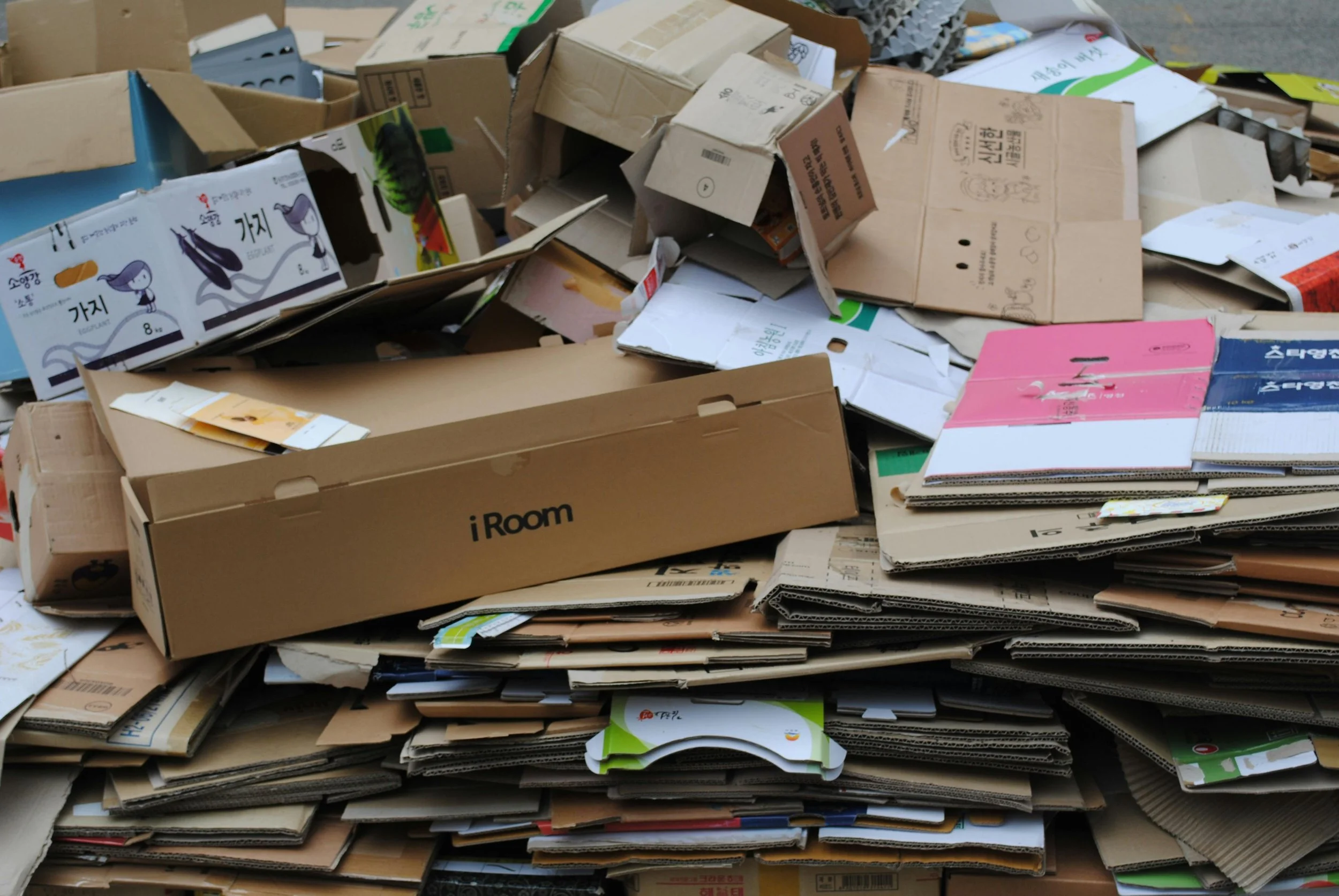 Pile of flattened cardboard boxes and packaging materials, some with printed labels and designs.